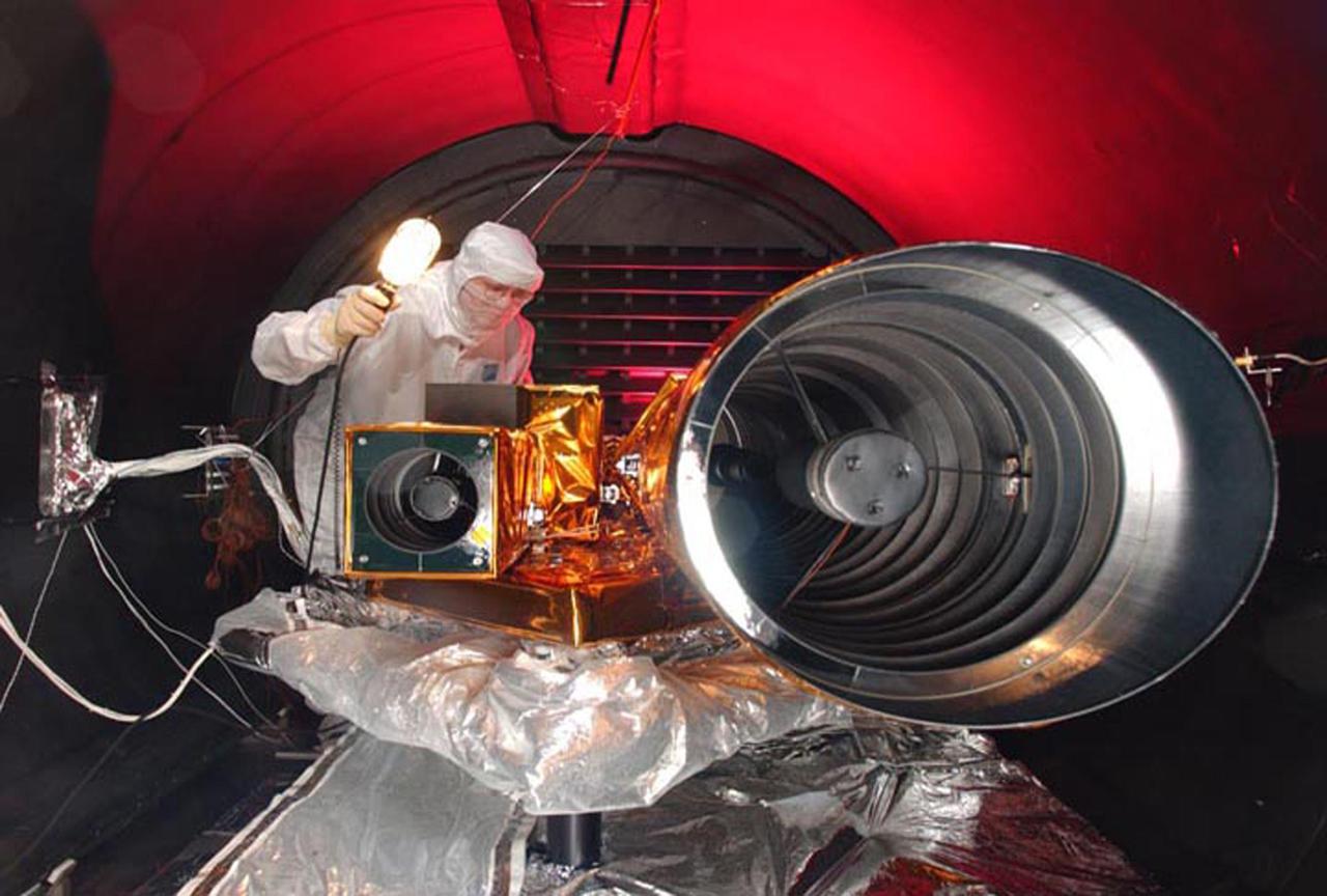 JET PROPULSION LABORATORY, CALIF. - At Ball Aerospace in Boulder, Colo., a thermal vacuum test is conducted on Deep Impact instruments in the instrument assembly area in the Fisher Assembly building clean room. The High Resolution Instrument (HRI, at right) is one of the largest space-based instruments built specifically for planetary science.  It is the main science camera for Deep Impact, providing the highest resolution images via a combined visible camera, an infrared spectrometer and a special imaging module. Deep Impact will probe beneath the surface of Comet Tempel 1 on July 4, 2005, when the comet is 83 million miles from Earth, and reveal the secrets of its interior. After releasing a 3- by 3-foot projectile (impactor) to crash onto the surface, Deep Impact’s flyby spacecraft will collect pictures and data of how the crater forms, measuring the crater’s depth and diameter, as well as the composition of the interior of the crater and any material thrown out, and determining the changes in natural outgassing produced by the impact.  Deep Impact is a NASA Discovery mission.  Launch of Deep Impact is scheduled for Jan. 12 from Launch Pad 17-B, Cape Canaveral Air Force Station, Fla.