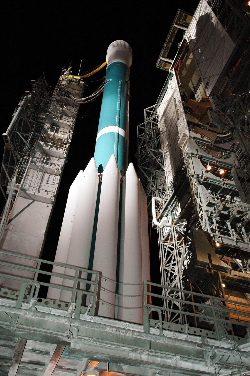 KENNEDY SPACE CENTER, FLA.  -  On Launch Pad 17-B, Cape Canaveral Air Force Station, Fla., the Boeing Delta II rocket carrying the Deep Impact spacecraft looms into the night sky as the mobile service tower at right is rolled back before launch. Scheduled for liftoff at 1:47 p.m. EST today, Deep Impact will head for space and a rendezvous with Comet Tempel 1 when the comet is 83 million miles from Earth.  After releasing a 3- by 3-foot projectile (impactor) to crash onto the surface July 4, 2005, Deep Impact’s flyby spacecraft will reveal the secrets of the comet’s interior by collecting pictures and data of how the crater forms, measuring the crater’s depth and diameter as well as the composition of the interior of the crater and any material thrown out, and determining the changes in natural outgassing produced by the impact.  It will send the data back to Earth through the antennas of the Deep Space Network.  Deep Impact is a NASA Discovery mission.