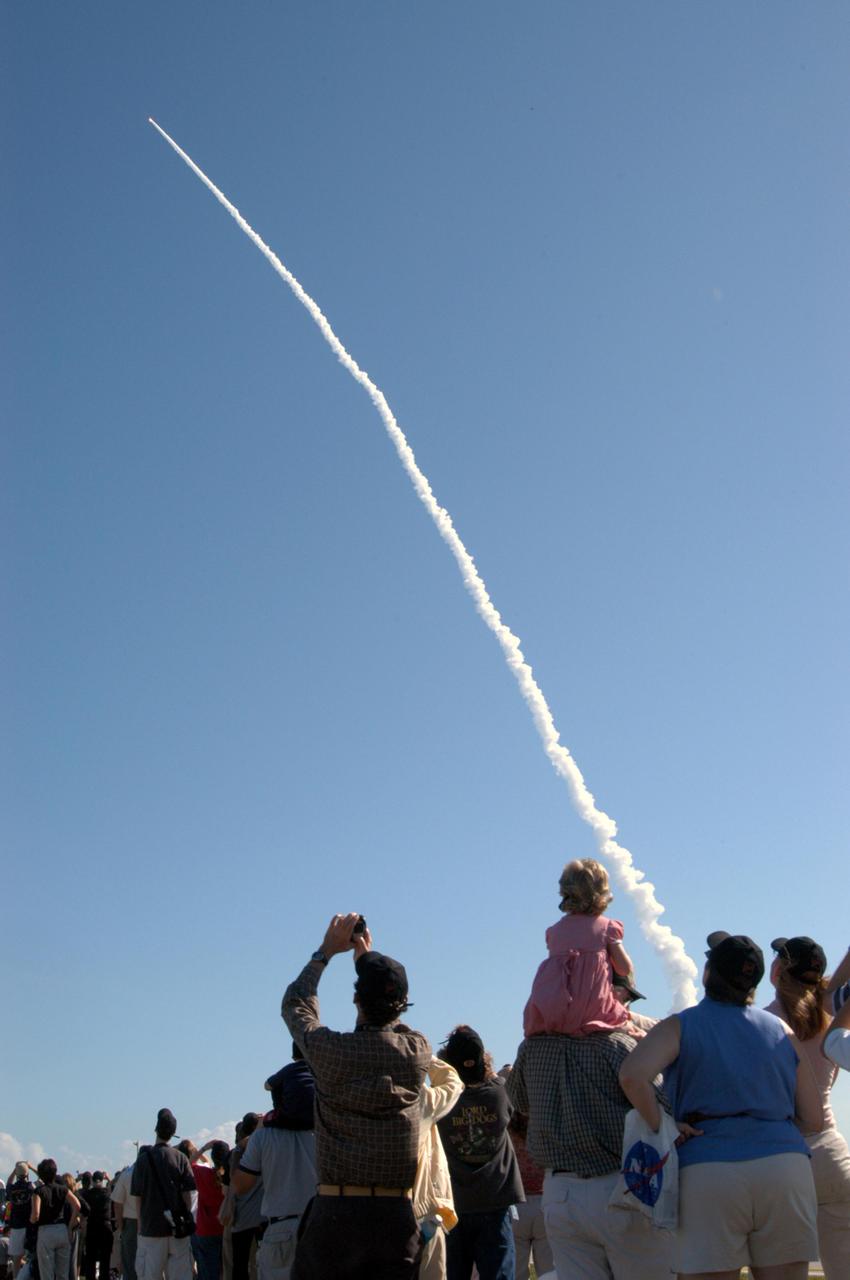 KENNEDY SPACE CENTER, FLA. - Guests of NASA gather near the launch site at Cape Canaveral Air Force Station, Fla., to watch the Deep Impact spacecraft as it speeds through the air after a perfect launch at 1:47 p.m. EST. A NASA Discovery mission, Deep Impact is heading for space and a rendezvous 83 million miles from Earth with Comet Tempel 1. After releasing a 3- by 3-foot projectile (impactor) to crash onto the surface July 4, 2005, Deep Impact’s flyby spacecraft will reveal the secrets of the comet’s interior by collecting pictures and data of how the crater forms, measuring the crater’s depth and diameter as well as the composition of the interior of the crater and any material thrown out, and determining the changes in natural outgassing produced by the impact. It will send the data back to Earth through the antennas of the Deep Space Network.