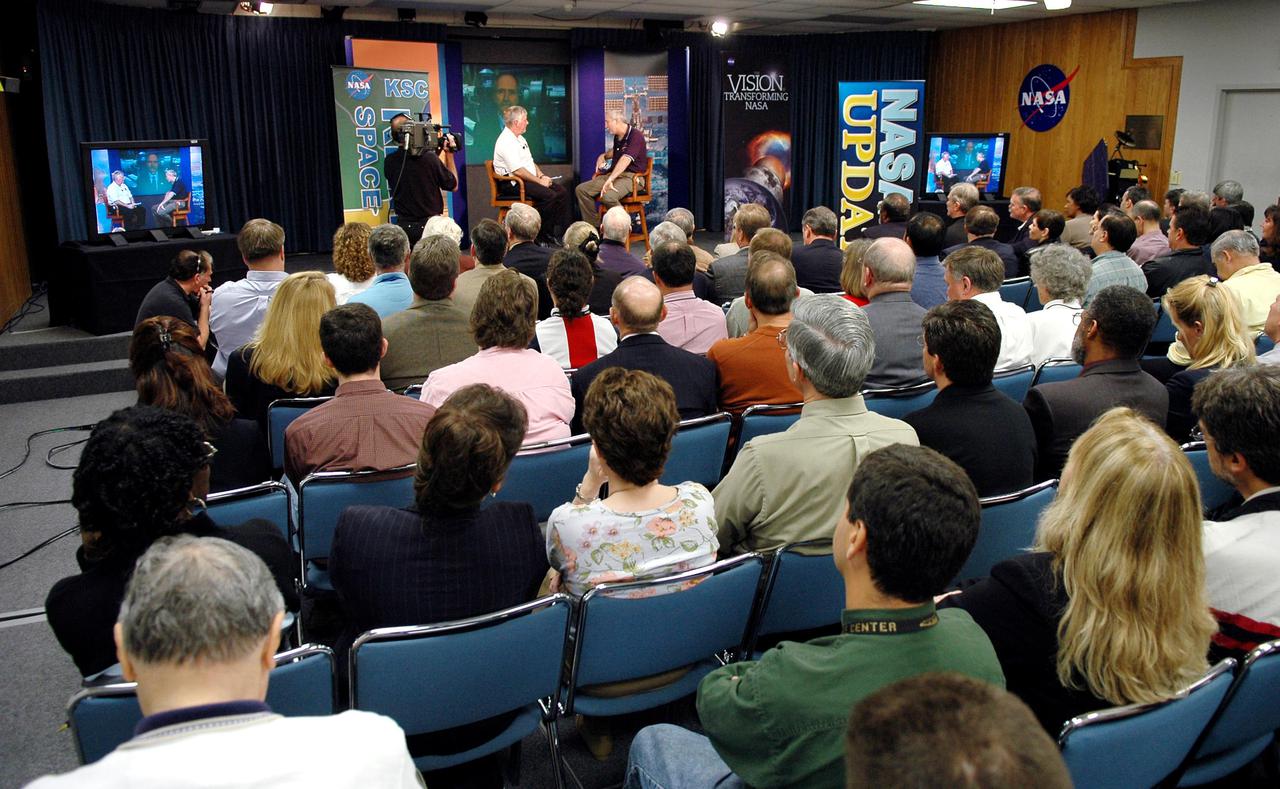 KENNEDY SPACE CENTER, FLA.  -  NASA Administrator Sean O’Keefe (right) is accompanied on stage in the Press Site Auditorium by Center Director Jim Kennedy for a report to employees on the state of the Agency. The update was broadcast live via NASA Television. O'Keefe focused on the achievements of 2004 and the goals set for 2005.  His remarks emphasized the milestones met in NASA's Vision for Space Exploration, including the launch of the comet-chasing Deep Impact mission and the landing of the Huygens probe on Jupiter’s moon Titan, both occurring in the past two days, and the progress made in meeting the requirements to return the Space Shuttle to flight.  O’Keefe’s briefing included a dialogue with Associate Administrator of NASA’s Office of Exploration Systems Craig Steidle and Center Director Jim Kennedy, live; and Manager of the Space Station Office Bill Gerstenmaier and Director of Advanced Planning and Jet Propulsion Laboratory Charles Elachi, via satellite.