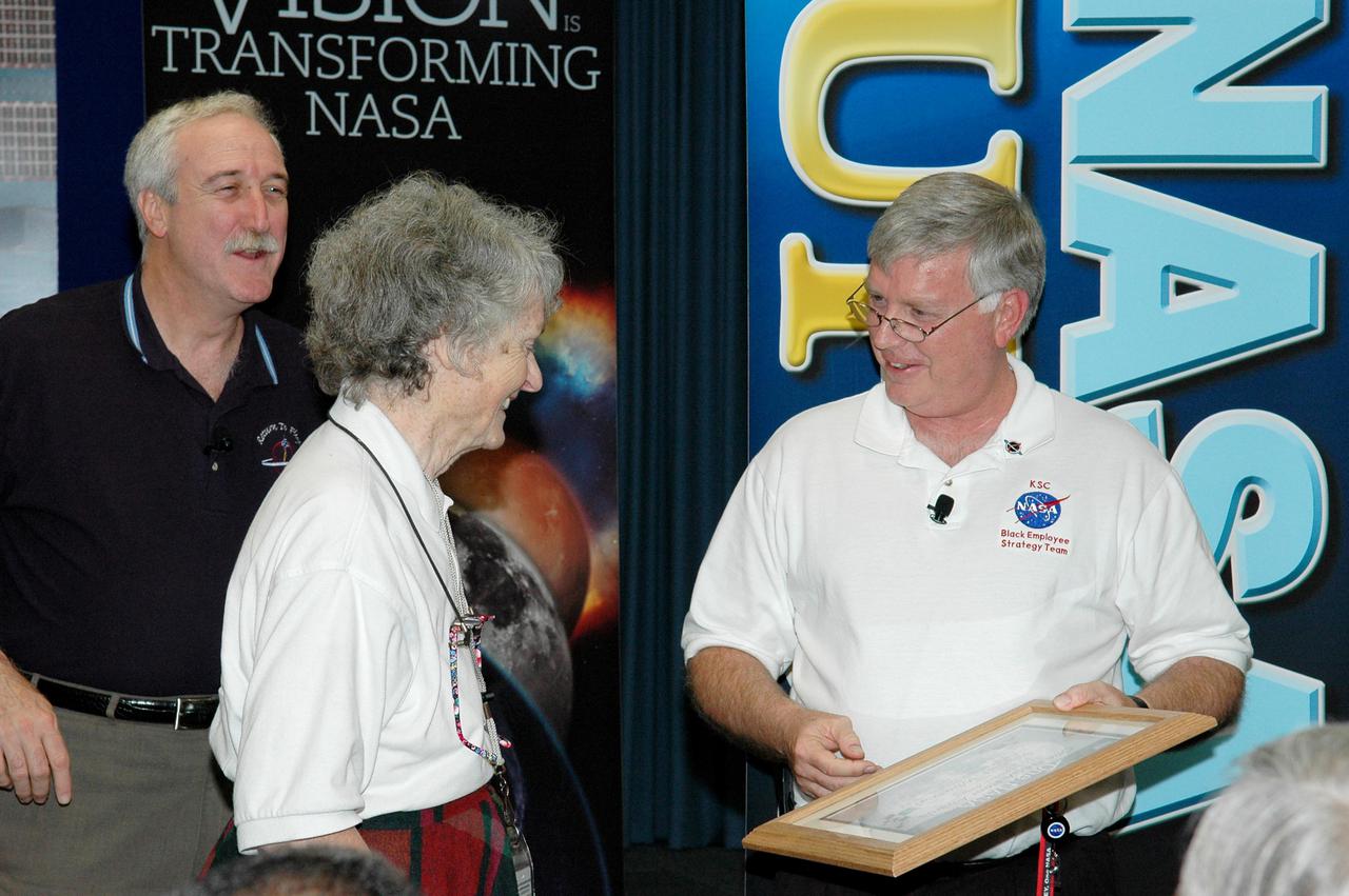 KENNEDY SPACE CENTER, FLA. - After the NASA Update by Administrator Sean O’Keefe (left), Center Director Jim Kennedy (right) presented a One NASA Peer Award to Virginia Whitehead for her outstanding customer service. Whitehead is a manager in the Center’s Payload Processing Directorate. The award is given to recognize employees who have demonstrated behaviors consistent with the spirit of One NASA and are called Peer Awards because candidates must be nominated by their peers.
