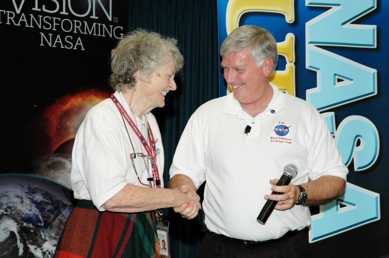 KENNEDY SPACE CENTER, FLA.  -  Center Director Jim Kennedy (right) congratulates Virginia Whitehead upon her receipt of a One NASA Peer Award. The award recognizes Whitehead for her outstanding customer service. Whitehead is a manager in the Center’s Payload Processing Directorate. The award was presented in the Press Site Auditorium following the NASA Update by NASA Administrator Sean O'Keefe. The award is given to recognize employees who have demonstrated behaviors consistent with the spirit of One NASA and are called Peer Awards because candidates must be nominated by their peers.