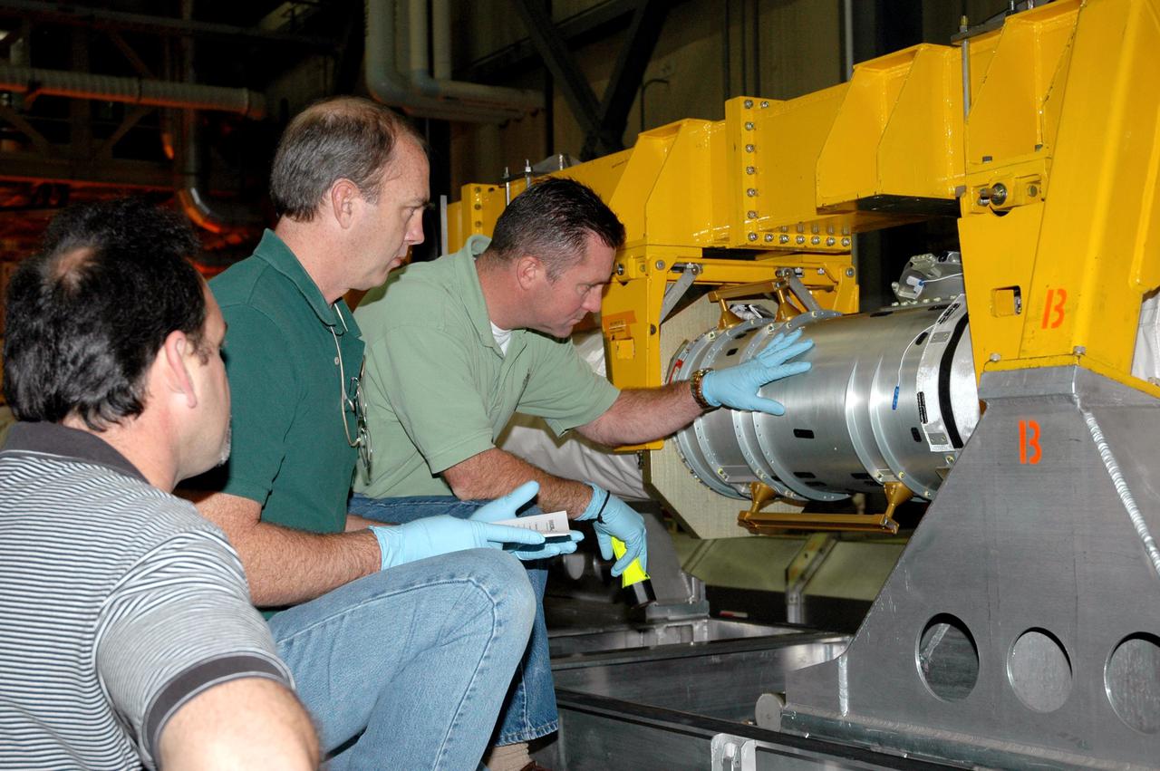 KENNEDY SPACE CENTER, FLA. - In the back transfer aisle of the Orbiter Processing Facility bay 3, workers check an area of the Orbiter Boom Sensor System (OBSS) that will be wrapped with a Thermal Protection System (TPS) blanket. The installation will conclude TPS closeout prior to installation of the boom in the orbiter Discovery. The OBSS is one of the new safety measures for Return to Flight, equipping the Shuttle with cameras and laser systems to inspect the Shuttle’s Thermal Protection System while in space. Discovery is designated as the Return to Flight vehicle for mission STS-114, with a launch window of May 12 to June 3, 2005.