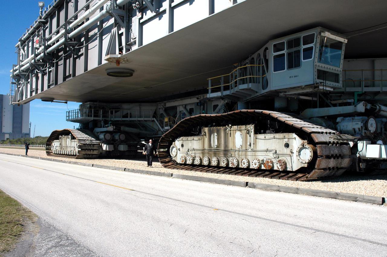 KENNEDY SPACE CENTER, FLA.  - Workers accompany the Crawler Transporter that will move Space Shuttle Discovery to the launch pad for Return to Flight as it demonstrates its readiness for weight bearing by carrying an unloaded 8,230,000-pound Mobile Launch Platform along the crawlerway. Its first road test on Jan. 21, following the replacement of all its shoes, was a success. Cracks appeared in the crawlers' shoes in recent years, spurring a need for replacement. The new manufacturer, in Duluth, Minn., has improved the design for a safe Return to Flight and use through the balance of the Space Shuttle Program. Each crawler has 456 shoes, 57 per belt (8 belts in all). Each shoe weighs 2,200 pounds.