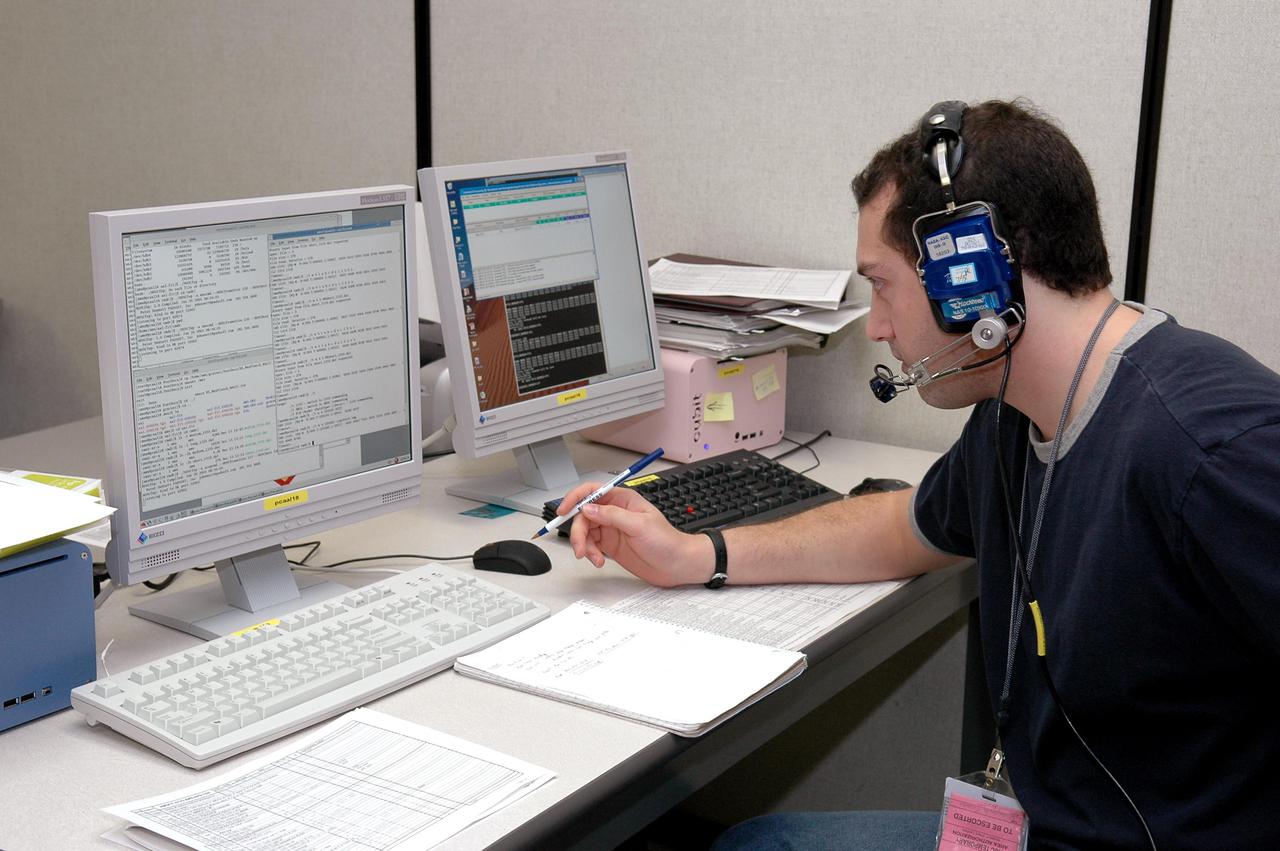 KENNEDY SPACE CENTER, FLA. - An employee at the Space Station Processing Facility monitors engineering certification testing of the Alpha Magnetic spectrometer (AMS). The AMS is a superconducting magnet that will be used in an experiment from the International Space Station (ISS) to search for antimatter and dark matter in space. The testing is being performed to ensure that data flow from the external payload AMS and the internal AMS crew operation post can be successfully routed through the ISS systems.