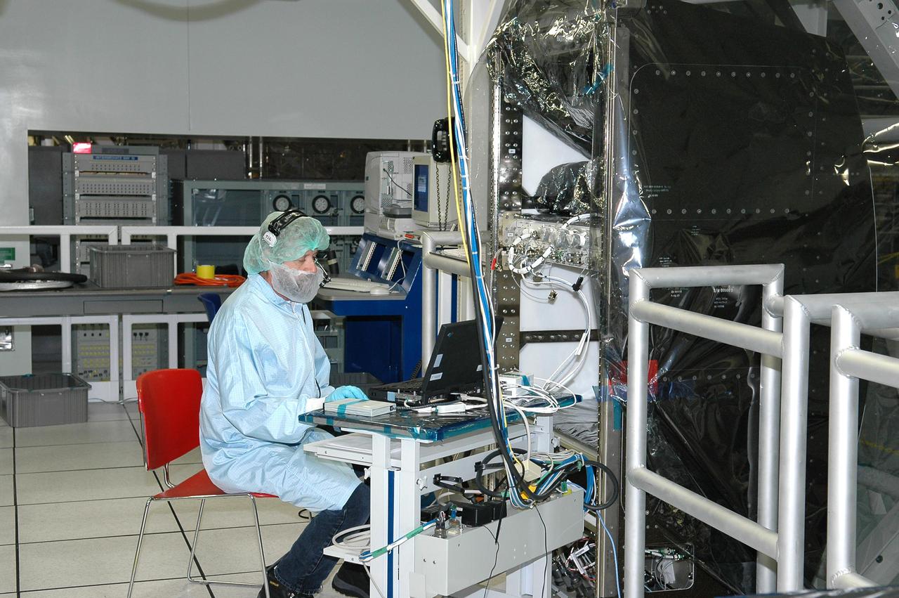KENNEDY SPACE CENTER, FLA. - An employee at the Space Station Processing Facility performs engineering certification testing of the Alpha Magnetic spectrometer (AMS). The AMS is a superconducting magnet that will be used in an experiment from the International Space Station (ISS) to search for antimatter and dark matter in space. The testing is being performed to ensure that data flow from the external payload AMS and the internal AMS crew operation post can be successfully routed through the ISS systems.