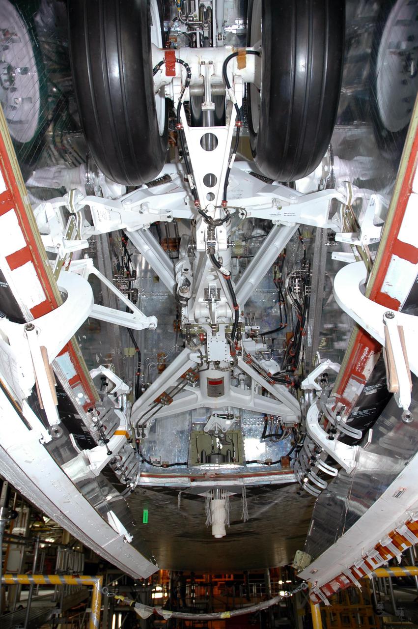 KENNEDY SPACE CENTER, FLA.  - The Forward Attach Point (hanging down from a point behind the nose landing gear) is installed on the orbiter Discovery. The equipment attaches the External Tank to the orbiter.  Discovery is the orbiter designated for the Return to Flight mission, STS-114.  The launch window is May 12 to June 3, 2005.
