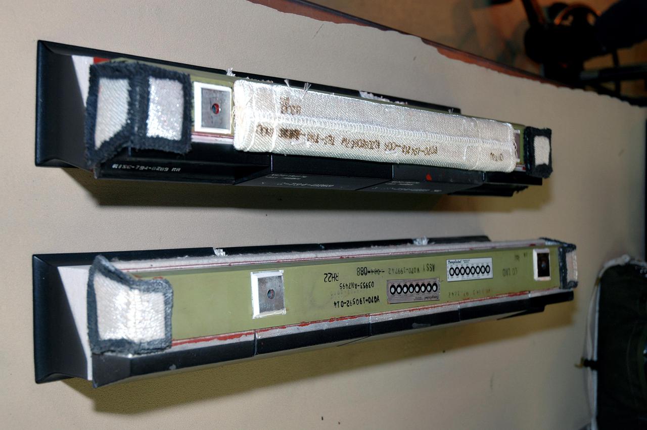 KENNEDY SPACE CENTER, FLA. - Old and new carrier panels sit side by side in the Orbiter Processing Facility. The new one in the foreground shows the added thermal barrier that performs as a flow restrictor to further protect the wing leading edges. The panels fit between the Reinforced Carbon Carbon panels and the vehicle on both the top and bottom. They are being installed on the orbiter Discovery. The change is one of the safety features for return to flight. Discovery is the orbiter designated for the Return to Flight mission, STS-114. The launch window is May 12 to June 3, 2005.