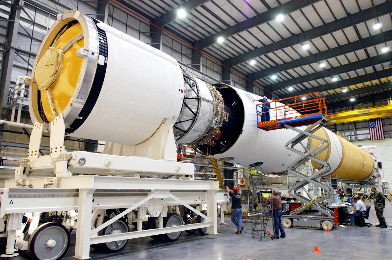 KENNEDY SPACE CENTER, FLA. - In the Horizontal Integration Facility, technicians watch closely as the GOES-N_Boeing Delta IV second stage (left) moves closer to the first stage to which it will be mated. The Boeing Delta IV rocket will be used for the 2005 launching of the GOES-N weather satellite for NASA and NOAA (National Oceanic and Atmospheric Administration). The first in a series of three advanced weather satellites that include GOES-O and GOES-P, the GOES-N will provide continuous monitoring necessary for intensive data analysis. It will provide a constant vigil for the atmospheric “triggers” of severe weather conditions such as tornadoes, flash floods, hail storms and hurricanes. When these conditions develop, GOES-N will be able to monitor storm development and track their movements. Launch of GOES-N is scheduled for May 4 from Cape Canaveral Air Force Station.