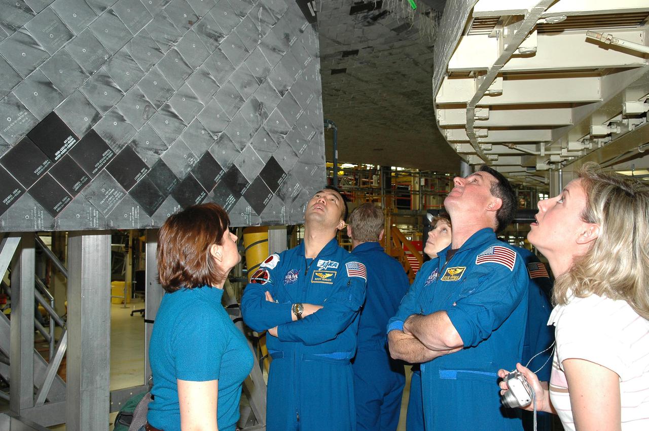 KENNEDY SPACE CENTER, FLA.  - In the Orbiter Processing Facility, members of the STS-114 crew look at Discovery, the orbiter designated for the Return to Flight mission.  The crew members seen in front are Mission Specialists Soichi Noguchi (with the Japanese Space Agency) and Stephen Robinson; in back are Mission Specialist Andrew Thomas (back to camera) and Commander Eileen Collins.  With them are Cindy Begley (left), lead EVA flight controller, and Christi Hansen (right), EVA trainer.  The crew is at KSC for Crew Equipment Interface Test activities.  During CEIT, the crew has an opportunity to get a hands-on look at the orbiter and equipment they will be working with on the mission.  Return to Flight Mission STS-114 will carry the Multi-Purpose Logistics Module Raffaello, filled with supplies for the International Space Station, and a replacement Control Moment Gyroscope.  Launch of STS-114 has a launch window of May 12 to June 3.
