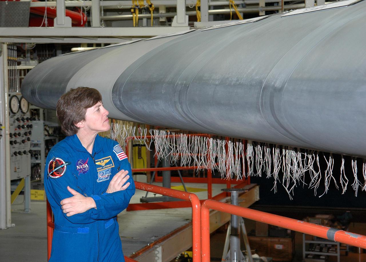 KENNEDY SPACE CENTER, FLA.  - In the Orbiter Processing Facility, STS-114 Mission Specialist Wendy Lawrence looks closely at Discovery’s wing leading edge.  The leading edge panels of the orbiters’ wings have 22 Reinforced Carbon-Carbon panels, made entirely of carbon composite material. The molded components are approximately 0.25-inch to 0.5-inch thick.  Lawrence and other crew members are at KSC for Crew Equipment Interface Test activities.   During CEIT, the crew has an opportunity to get a hands-on look at the orbiter and equipment they will be working with on the mission.  Return to Flight Mission STS-114 will carry the Multi-Purpose Logistics Module Raffaello, filled with supplies for the International Space Station, and a replacement Control Moment Gyroscope.  Launch of STS-114 has a launch window of May 12 to June 3.