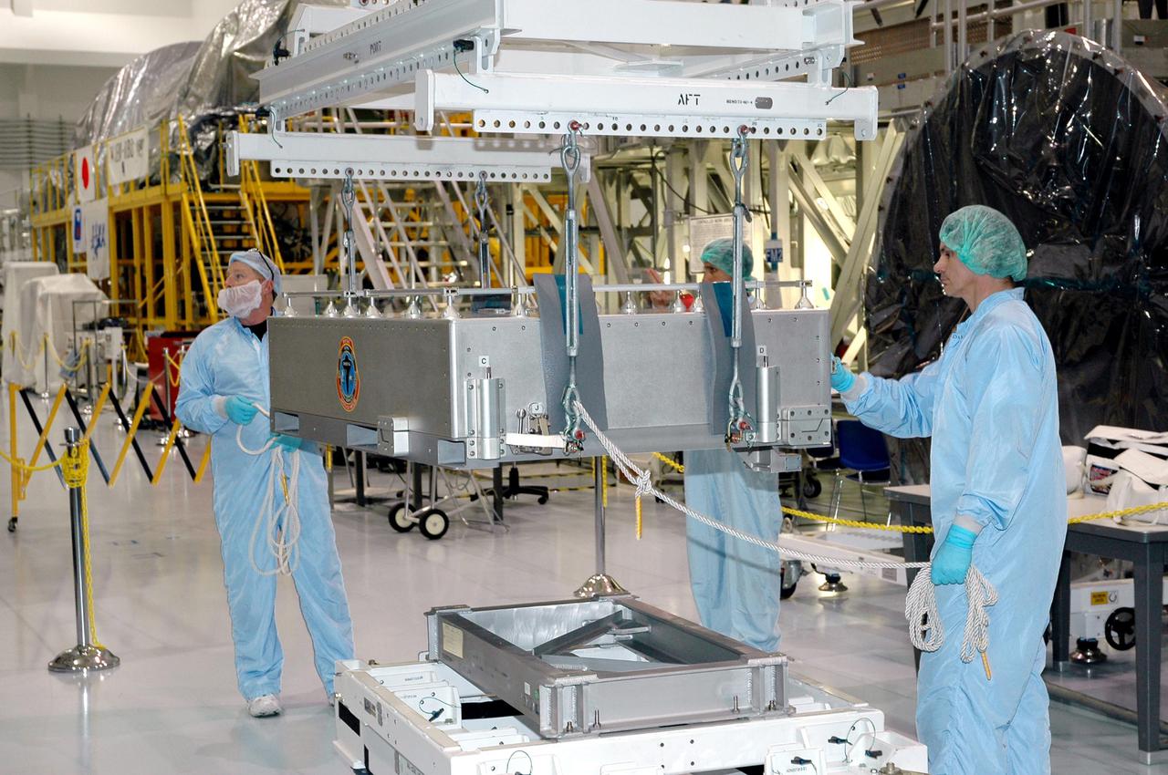 KENNEDY SPACE CENTER, FLA.  - Technicians at the Space Station Processing Facility prepare the Thermal Protection System Detailed Test Objective (DTO) box to be lifted onto the Lightweight Multi-Purpose Experiment Support Structure Carrier (LMC).  It will be placed on the Lightweight Multi-Purpose Experiment Support Structure Carrier (LMC) to fly on Space Shuttle Discovery for mission STS-114.  The DTO contains tile samples that will enable astronauts to test new on-orbit Thermal Protection System repair techniques.  The launch window for mission STS-114 is May 12 to June 3.