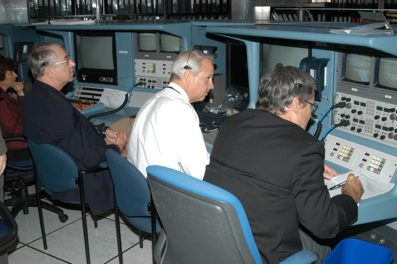 KENNEDY SPACE CENTER, FLA.  -  Sitting at consoles, journalists Marsha Dunn, Craig Covault, Mike Cabbage and Bill Harwood witness an End-to-End (ETE) Mission Management Team (MMT) launch simulation at KSC.  In Firing Room 1 at KSC, Shuttle launch team members put the Shuttle system through an integrated simulation. The control room is set up with software used to simulate flight and ground systems in the launch configuration.  The ETE MMT simulation included L-2 and L-1 day Prelaunch MMT meetings, an external tanking_weather briefing, and a launch countdown.  The ETE transitioned to the Johnson Space Center for the flight portion of the simulation, with the STS-114 crew in a simulator at JSC.  Such simulations are common before a launch to keep the Shuttle launch team sharp and ready for liftoff.