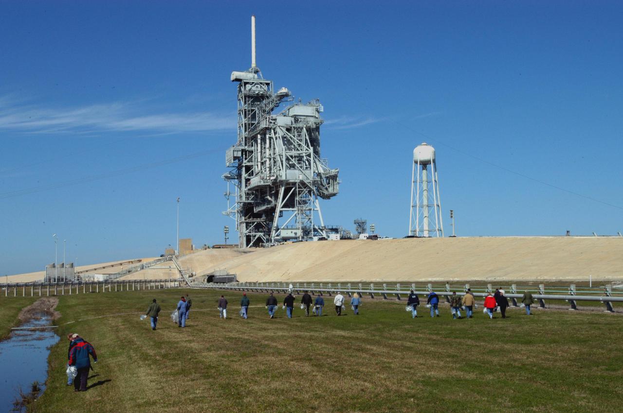 KENNEDY SPACE CENTER, FLA.  -  Preparing for Return to Flight, workers at KSC walk the grounds around Launch Pad 39B looking for Foreign Object Debris, or FOD.  The pad was recently refurbished and any possible debris left behind must be removed from the area prior to launch.  Foreign objects that are alien to flight systems may cause material damage or may make the system or equipment inoperable, unsafe or less efficient. The Return to Flight mission STS-114 aboard Space Shuttle Discovery will carry supplies and equipment to the International Space Station.  Discovery is scheduled for launch in a window from May 15 to June 3.