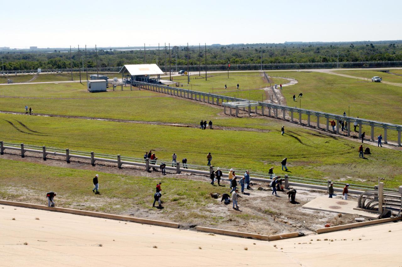 KENNEDY SPACE CENTER, FLA.  -  Preparing for Return to Flight, workers at KSC walk the grounds around Launch Pad 39B looking for and picking up Foreign Object Debris, or FOD.  The pad was recently refurbished and any possible debris left behind must be removed from the area prior to launch.  Foreign objects that are alien to flight systems may cause material damage or may make the system or equipment inoperable, unsafe or less efficient. The Return to Flight mission STS-114 aboard Space Shuttle Discovery will carry supplies and equipment to the International Space Station.  Discovery is scheduled for launch in a window from May 15 to June 3.