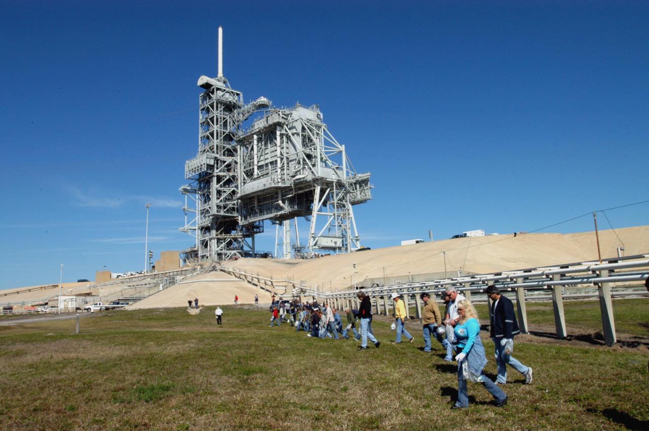 KENNEDY SPACE CENTER, FLA.  -  Preparing for Return to Flight, workers at KSC walk the grounds around Launch Pad 39B looking for Foreign Object Debris, or FOD.  The pad was recently refurbished and any possible debris left behind must be removed from the area prior to launch.  Foreign objects that are alien to flight systems may cause material damage or may make the system or equipment inoperable, unsafe or less efficient. The Return to Flight mission STS-114 aboard Space Shuttle Discovery will carry supplies and equipment to the International Space Station.  Discovery is scheduled for launch in a window from May 15 to June 3.