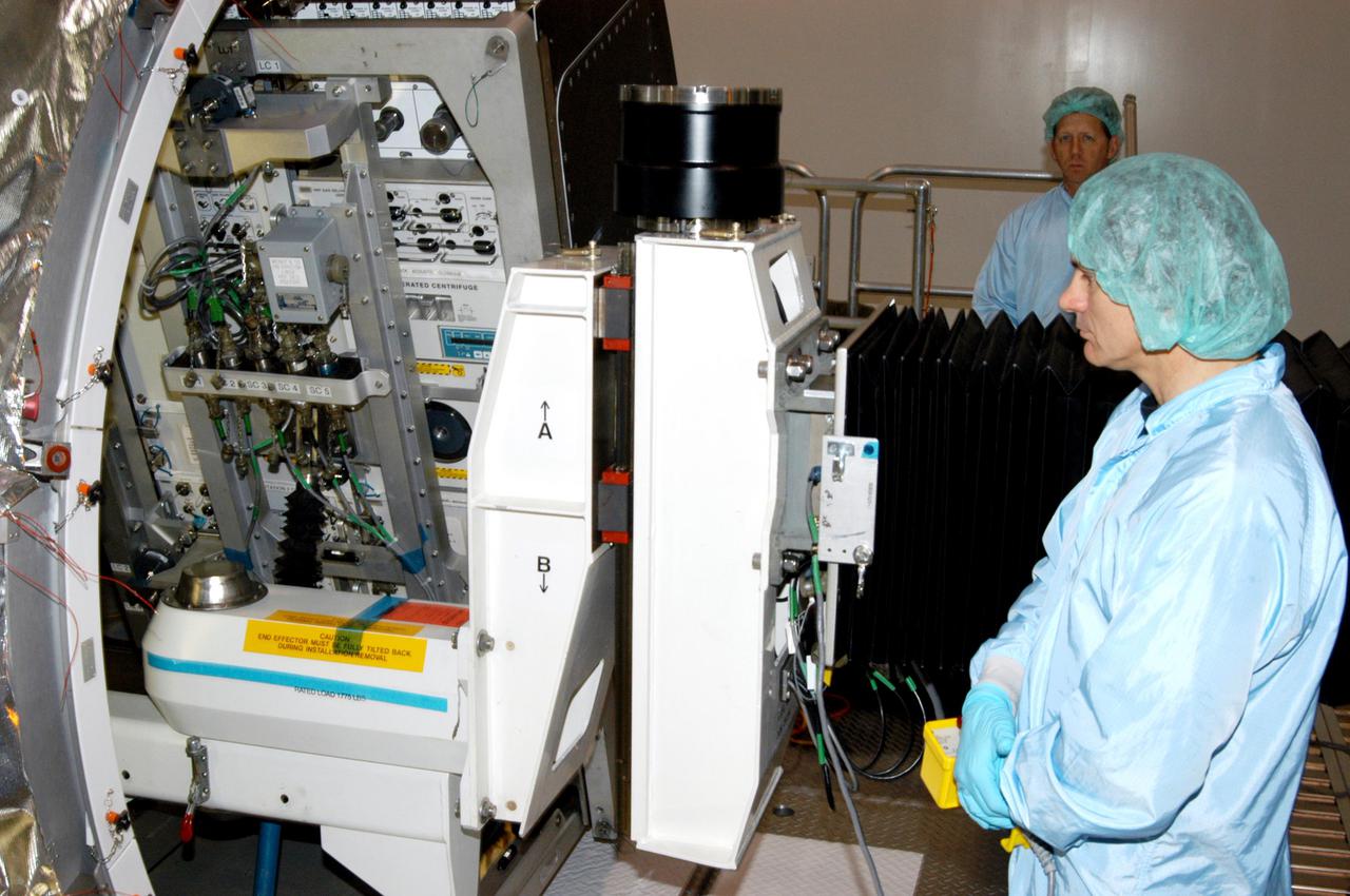 KENNEDY SPACE CENTER, FLA. - In the Space Station Processing Facility, a worker watches as the Rack Insertion Device slowly moves the Human Research Facility-2 (HRF-2) science rack into the Multi-Purpose Logistics Module Raffaello for flight on Space Shuttle Discovery’s Return to Flight mission, STS-114. The HRF-2 will deliver additional biomedical instrumentation and research capability to the International Space Station. HRF-1, installed on the U.S. Lab since May 2001, contains an ultrasound unit and gas analyzer. Both racks provide structural, power, thermal, command and data handling, and communication and tracking interfaces between the HRF biomedical instrumentation and the U.S. Laboratory, Destiny. NASA Kennedy Space Center and their prime contractor responsible for ISS element processing, The Boeing Company, prepared the rack for installation. The HRF Project is managed by NASA Johnson Space Center and implemented through contract with Lockheed Martin, Houston, Texas.