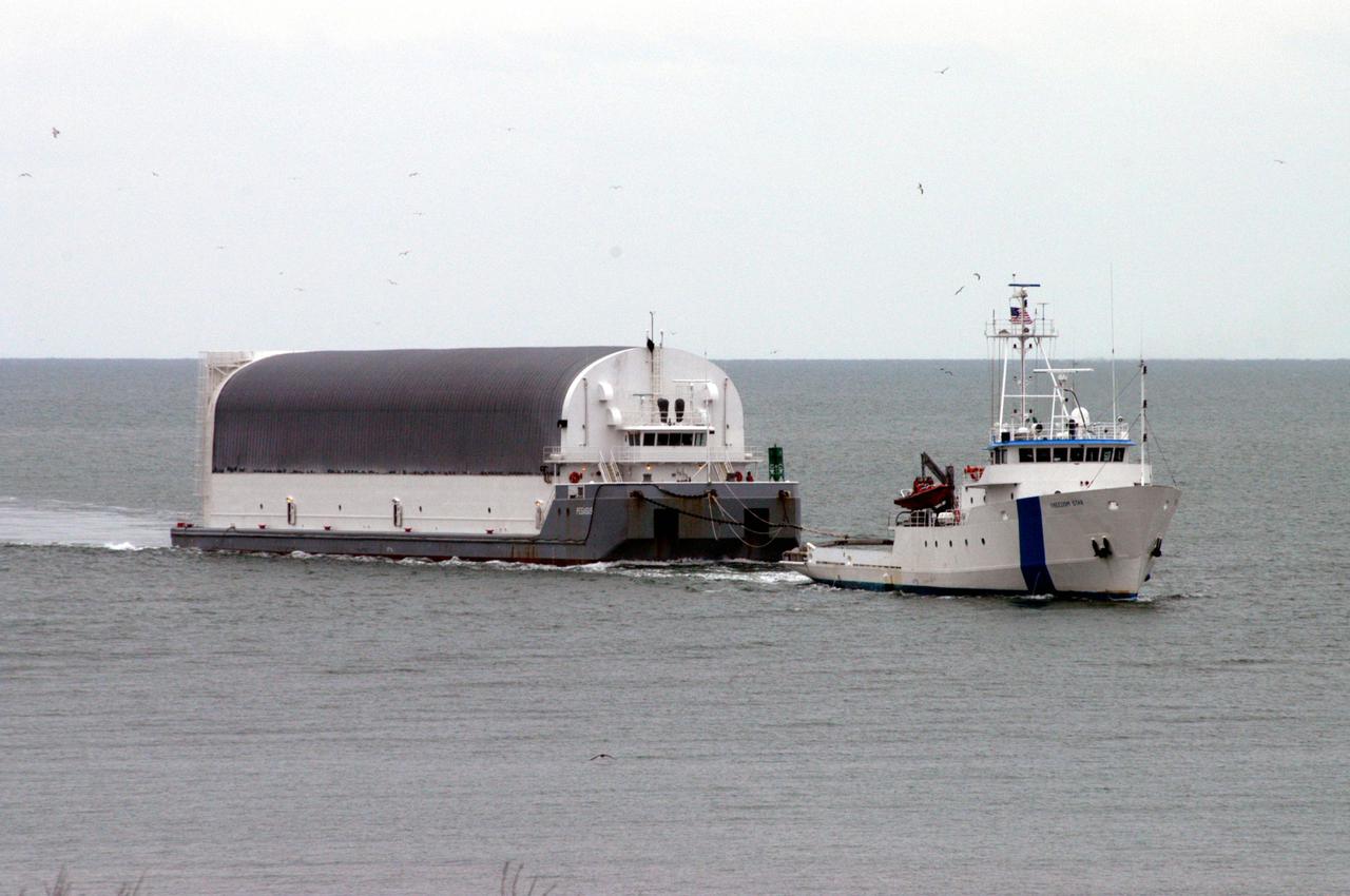 KENNEDY SPACE CENTER, FLA. - The barge carrying a newly redesigned External Tank (ET-121) designated for use on Return to Flight mission STS-121 approaches Port Canaveral after its 900-mile journey at sea from the Michoud Assembly Facility in New Orleans. It is being towed by NASA’s Solid Rocket Booster Retrieval Ship Freedom Star. At Port Canaveral, the barge will be hooked up to tugs for the last part of the journey to the Launch Complex 39 Area Turn Basin at NASA’s Kennedy Space Center. It will then be offloaded and transported to the Vehicle Assembly Building.