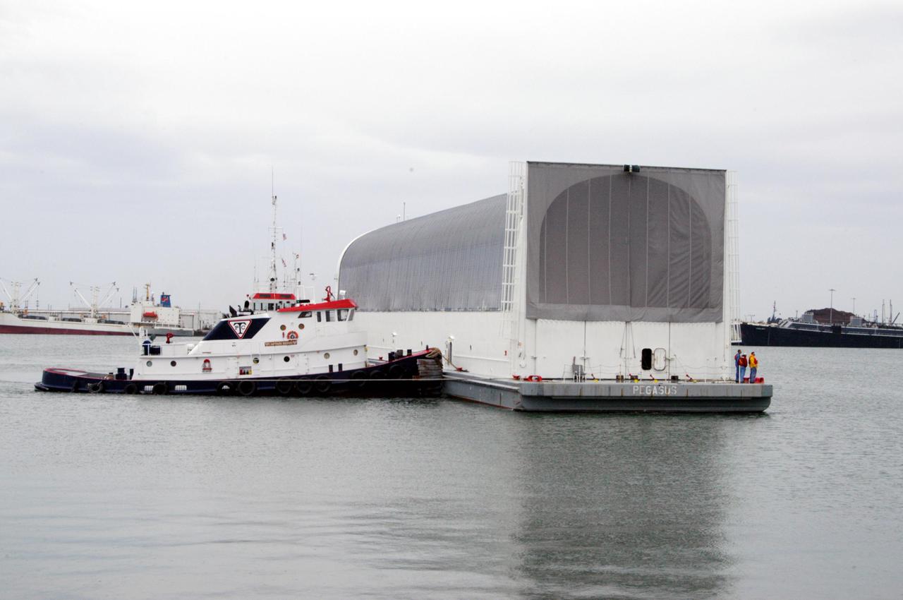 KENNEDY SPACE CENTER, FLA. - At Port Canaveral, a tug maneuvers the barge carrying a newly redesigned External Tank (ET-121) designated for use on Return to Flight mission STS-121. The barge was towed on a 900-mile journey at sea from the Michoud Assembly Facility in New Orleans by NASA’s Solid Rocket Booster Retrieval Ship Freedom Star. At Port Canaveral, the barge will be hooked up to tugs for the last part of the journey to the Launch Complex 39 Area Turn Basin at NASA’s Kennedy Space Center. It will then be offloaded and transported to the Vehicle Assembly Building.