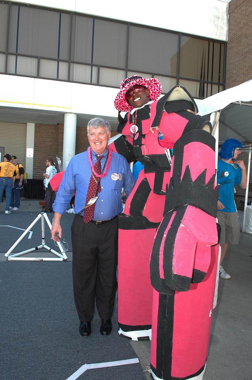 KENNEDY SPACE CENTER, FLA.  - During the 2005 FIRST Robotics Regional Competition held at the University of Central Florida March 10-12, Center Director Jim Kennedy (left) meets members of the NASA-sponsored Space Coast FIRST Robotics Team, known as the Pink Team. The Pink Team took first place in the competition as part of a three-team alliance and advances to the Championship in Atlanta in April. The Pink Team comprises students from Rockledge High School and Cocoa Beach Junior_Senior High School. NASA and the University of Central Florida are co-hosts of the regional event. The competition stages short games played by remote-controlled robots, which are designed and built in six weeks by a team of high school students and a handful of engineers-mentors. The students control the robots on the playing field.