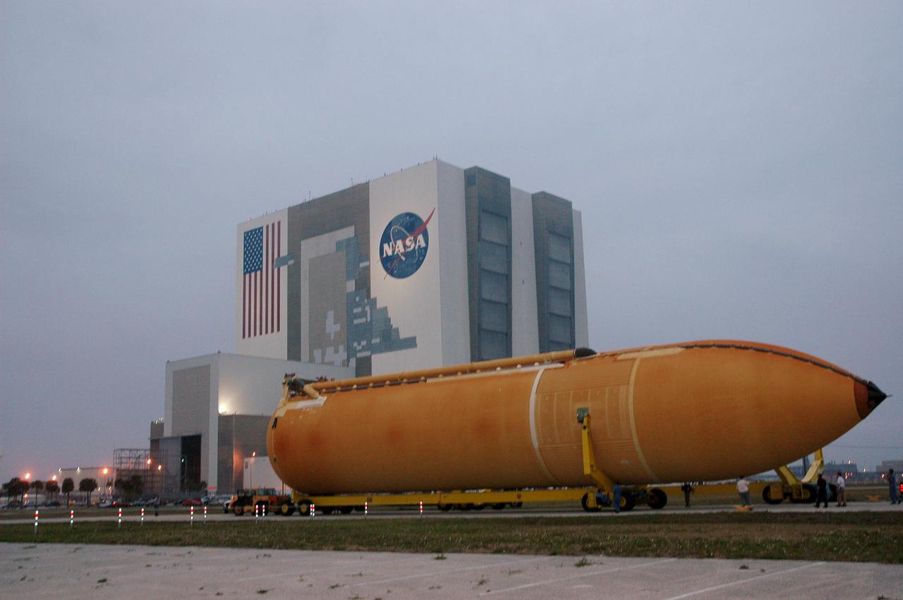 KENNEDY SPACE CENTER, FLA. -The second redesigned External Tank (ET-121) moves slowly on the road from the Turn Basin to the Vehicle Assembly Building in the background. The tank recently arrived at the Turn Basin aboard a barge after its 900-mile journey at sea from the Michoud Assembly Facility in New Orleans. In addition to the Return to Flight modifications, this tank has been outfitted with temperature sensors and accelerometers, used to measure vibration. These sensors will gather information about how the tank performs during flight. The tank is designated for use on Return to Flight mission STS-121, which has a launch window of July 12 to July 31, 2005.