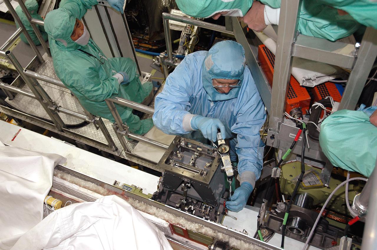 KENNEDY SPACE CENTER, FLA. - In the Orbiter Processing Facility at NASA’s Kennedy Space Center, technicians check out the base of the Manipulator Positioning Mechanism (MPM) installed on the starboard side of Atlantis’ payload bay. The MPM will hold the 50-foot-long Orbiter Boom Sensor System (OBSS) that will attach to the Remote Manipulator System, or Shuttle robotic arm. The OBSS is one of the new safety measures for Return to Flight, equipping the orbiter with cameras and laser systems to inspect the Shuttle's Thermal Protection System while in space. Atlantis is scheduled to fly on Return to Flight mission STS-121, which has a launch window of July 12 to July 31, 2005.