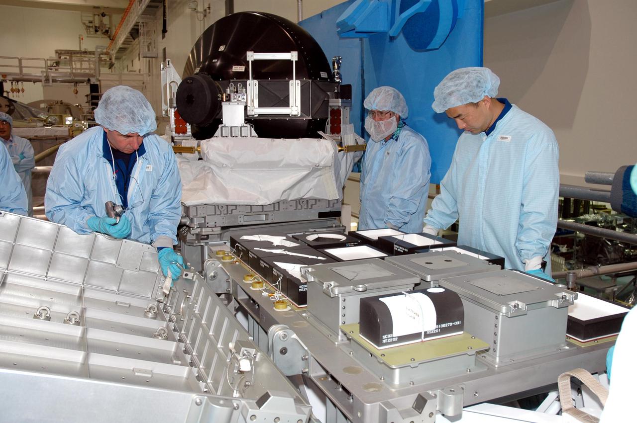 KENNEDY SPACE CENTER, FLA.  - Members of the Space Shuttle Discovery’s Return to Flight STS-114 crew are conducting a payload Crew Equipment Interface Test (CEIT) in the Space Station Processing Facility at NASA’s Kennedy Space Center, Fla.  Seen here looking at tile samples are Mission Specialists Stephen Robinson (left) and Soichi Noguchi (right), who is with the Japanese Aerospace Exploration Agency.  The launch window for STS-114 is May 15 to June 3, 2005.   During CEIT, the crew is inspecting the resupply stowage racks installed in the Italian-built Multi-Purpose Logistics Module Raffaello and performing tool and equipment interface checks with the Thermal Protection System (TPS) repair sample box, the Control Moment Gyroscope (CMG) and the External Stowage Platform-2 in preparation for the mission’s three scheduled spacewalks.  The seven-member crew will fly to the International Space Station primarily to evaluate procedures for flight safety, including Shuttle inspection and repair techniques.  The TPS repair sample box contains tile samples for the Detailed Test Objective (DTO) that will enable the crew to test new on-orbit TPS repair techniques.  The CMG installed on the Lightweight Multi-Purpose Experiment Support Structure Carrier (LMC) is a replacement for an inoperable CMG on the International Space Station.  The CMGs provide altitude control for the outpost keeping it properly oriented toward the Sun without use of rocket fuel.  The ESP2 will carry replacement parts, known as orbital replacement units (ORU) to the Station.  The platform will be deployed and attached to the Station’s airlock and will be used as a permanent spare parts facility.