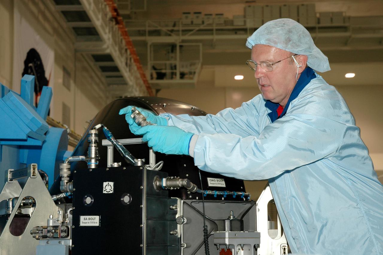 KENNEDY SPACE CENTER, FLA. - Members of the Space Shuttle Discovery’s Return to Flight STS-114 crew are conducting a payload Crew Equipment Interface Test (CEIT) in the Space Station Processing Facility at NASA’s Kennedy Space Center, Fla. Seen here is Mission Specialist Andrew Thomas, looking at the Control Moment Gyroscope, part of the mission payload. The launch window for STS-114 is May 15 to June 3, 2005. During CEIT, the crew is inspecting the resupply stowage racks installed in the Italian-built Multi-Purpose Logistics Module Raffaello and performing tool and equipment interface checks with the Thermal Protection System (TPS) repair sample box, the Control Moment Gyroscope (CMG) and the External Stowage Platform-2 in preparation for the mission’s three scheduled spacewalks. The seven-member crew will fly to the International Space Station primarily to evaluate procedures for flight safety, including Shuttle inspection and repair techniques. The TPS repair sample box contains tile samples for the Detailed Test Objective (DTO) that will enable the crew to test new on-orbit TPS repair techniques. The CMG installed on the Lightweight Multi-Purpose Experiment Support Structure Carrier (LMC) is a replacement for an inoperable CMG on the International Space Station. The CMGs provide altitude control for the outpost keeping it properly oriented toward the Sun without use of rocket fuel. The ESP2 will carry replacement parts, known as orbital replacement units (ORU) to the Station. The platform will be deployed and attached to the Station’s airlock and will be used as a permanent spare parts facility.