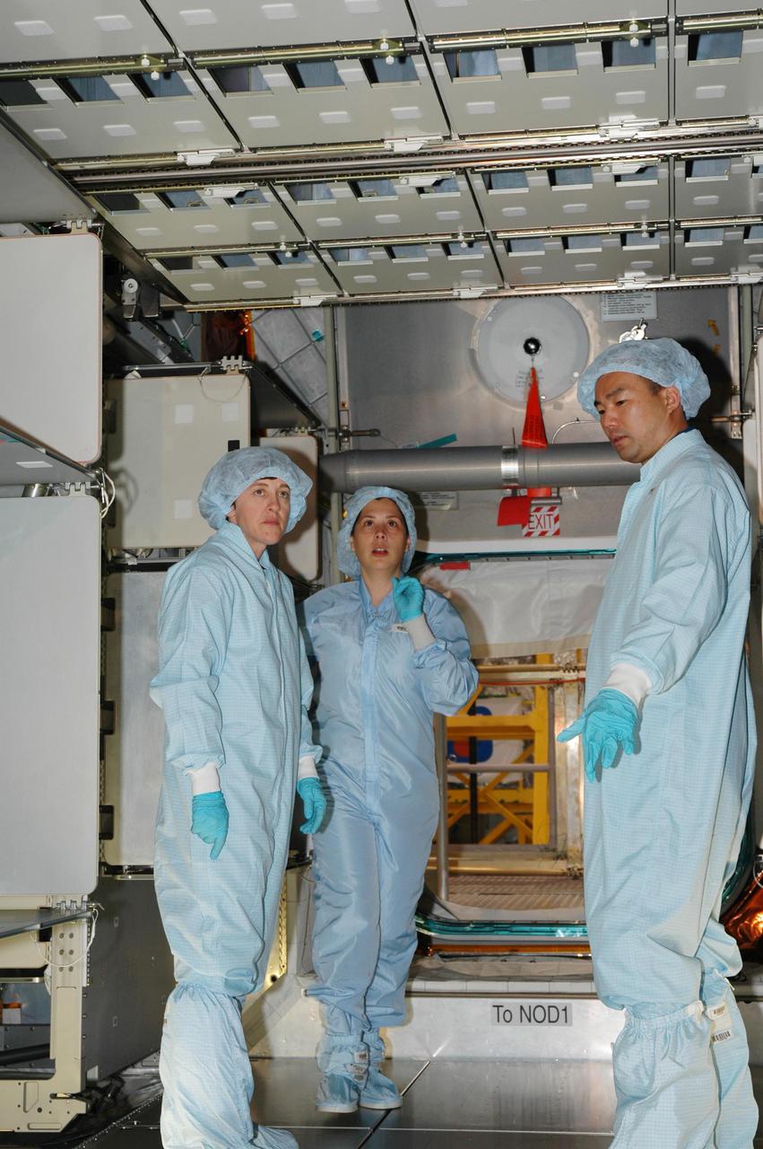 KENNEDY SPACE CENTER, FLA. - Members of the Space Shuttle Discovery’s Return to Flight STS-114 crew are conducting a payload Crew Equipment Interface Test (CEIT) in the Space Station Processing Facility at NASA’s Kennedy Space Center, Fla. Seen here inside the Multi-Purpose Logistics Module Raffaello are Mission Specialists Wendy Lawrence (left) and Soichi Noguchi (right), who is with the Japanese Aerospace Exploration Agency. The launch window for STS-114 is May 15 to June 3, 2005. During CEIT, the crew is inspecting the resupply stowage racks installed in the Italian-built Multi-Purpose Logistics Module Raffaello and performing tool and equipment interface checks with the Thermal Protection System (TPS) repair sample box, the Control Moment Gyroscope (CMG) and the External Stowage Platform-2 in preparation for the mission’s three scheduled spacewalks. The seven-member crew will fly to the International Space Station primarily to evaluate procedures for flight safety, including Shuttle inspection and repair techniques. The TPS repair sample box contains tile samples for the Detailed Test Objective (DTO) that will enable the crew to test new on-orbit TPS repair techniques. The CMG installed on the Lightweight Multi-Purpose Experiment Support Structure Carrier (LMC) is a replacement for an inoperable CMG on the International Space Station. The CMGs provide altitude control for the outpost keeping it properly oriented toward the Sun without use of rocket fuel. The ESP2 will carry replacement parts, known as orbital replacement units (ORU) to the Station. The platform will be deployed and attached to the Station’s airlock and will be used as a permanent spare parts facility.