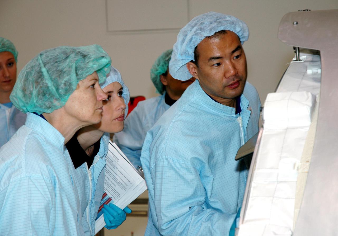 KENNEDY SPACE CENTER, FLA. - Members of the Space Shuttle Discovery’s Return to Flight STS-114 crew are conducting a payload Crew Equipment Interface Test (CEIT) in the Space Station Processing Facility at NASA’s Kennedy Space Center, Fla. Seen here are Commander Eileen Collins (left) and Mission Specialist Soichi Noguchi (right), who is with the Japanese Aerospace Exploration Agency. The launch window for STS-114 is May 15 to June 3, 2005. During CEIT, the crew is inspecting the resupply stowage racks installed in the Italian-built Multi-Purpose Logistics Module Raffaello and performing tool and equipment interface checks with the Thermal Protection System (TPS) repair sample box, the Control Moment Gyroscope (CMG) and the External Stowage Platform-2 in preparation for the mission’s three scheduled spacewalks. The seven-member crew will fly to the International Space Station primarily to evaluate procedures for flight safety, including Shuttle inspection and repair techniques. The TPS repair sample box contains tile samples for the Detailed Test Objective (DTO) that will enable the crew to test new on-orbit TPS repair techniques. The CMG installed on the Lightweight Multi-Purpose Experiment Support Structure Carrier (LMC) is a replacement for an inoperable CMG on the International Space Station. The CMGs provide altitude control for the outpost keeping it properly oriented toward the Sun without use of rocket fuel. The ESP2 will carry replacement parts, known as orbital replacement units (ORU) to the Station. The platform will be deployed and attached to the Station’s airlock and will be used as a permanent spare parts facility.