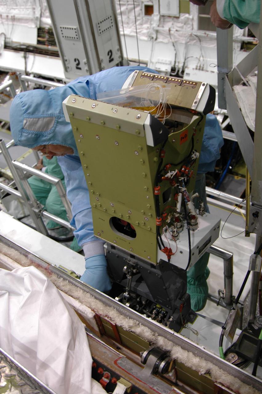 KENNEDY SPACE CENTER, FLA. - In the Orbiter Processing Facility at NASA’s Kennedy Space Center, technicians install the pedestal of the Manipulator Positioning Mechanism (MPM) on the starboard side of Atlantis’ payload bay. The MPM will hold the 50-foot-long Orbiter Boom Sensor System (OBSS) that will attach to the Remote Manipulator System, or Shuttle robotic arm. The OBSS is one of the new safety measures for Return to Flight, equipping the orbiter with cameras and laser systems to inspect the Shuttle's Thermal Protection System while in space. Atlantis is scheduled to fly on Return to Flight mission STS-121, which has a launch window of July 12 to July 31, 2005.