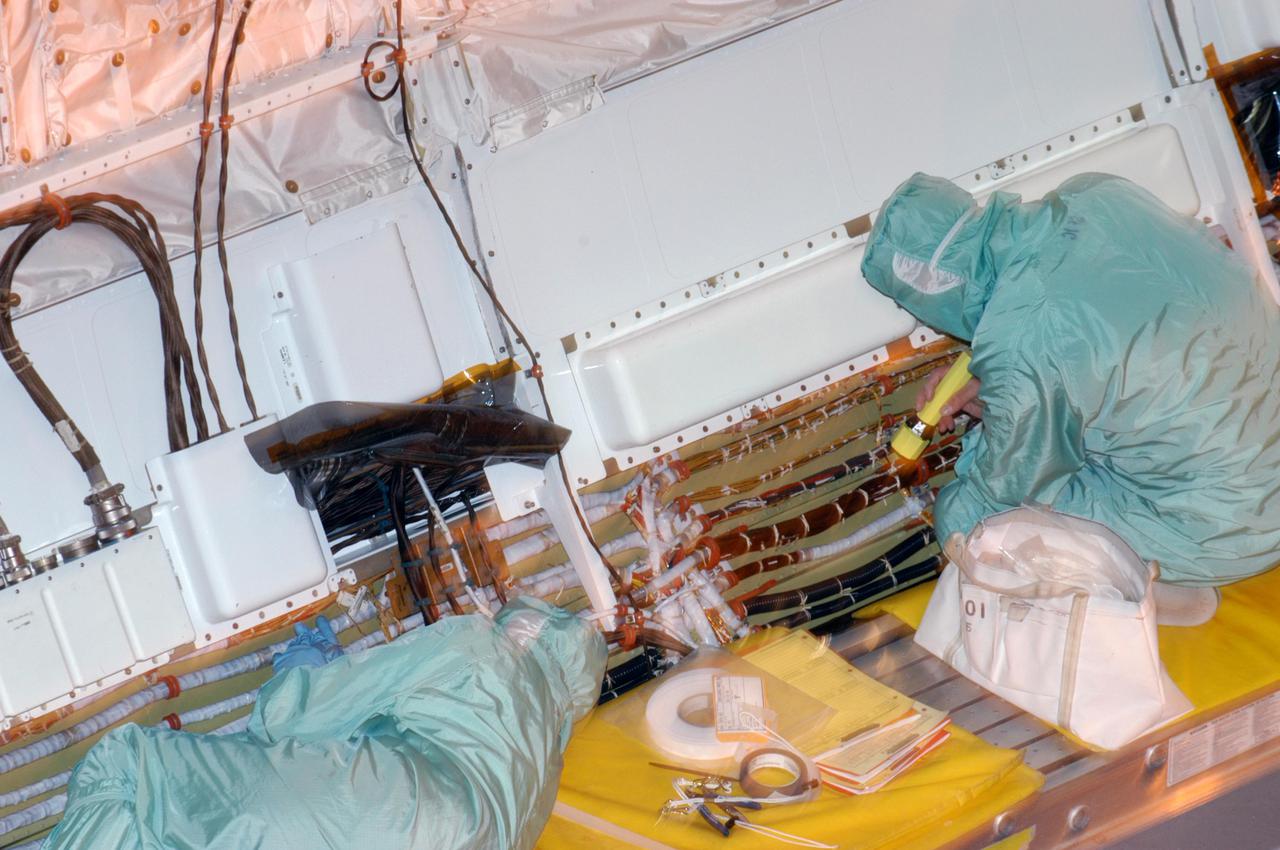 KENNEDY SPACE CENTER, FLA.  - In the Orbiter Processing Facility at NASA’s Kennedy Space Center in Florida, workers are removing wire tray covers on Discovery and adding chafe prevention.  Boroscope inspections revealed the need for the protection to prevent fasteners from causing minor chafing on the tubing surrounding the wires.  Discovery is the designated orbiter for Return to Flight mission STS-114 to the International Space Station.  The launch window for the mission is May 15 to June 3, 2005.