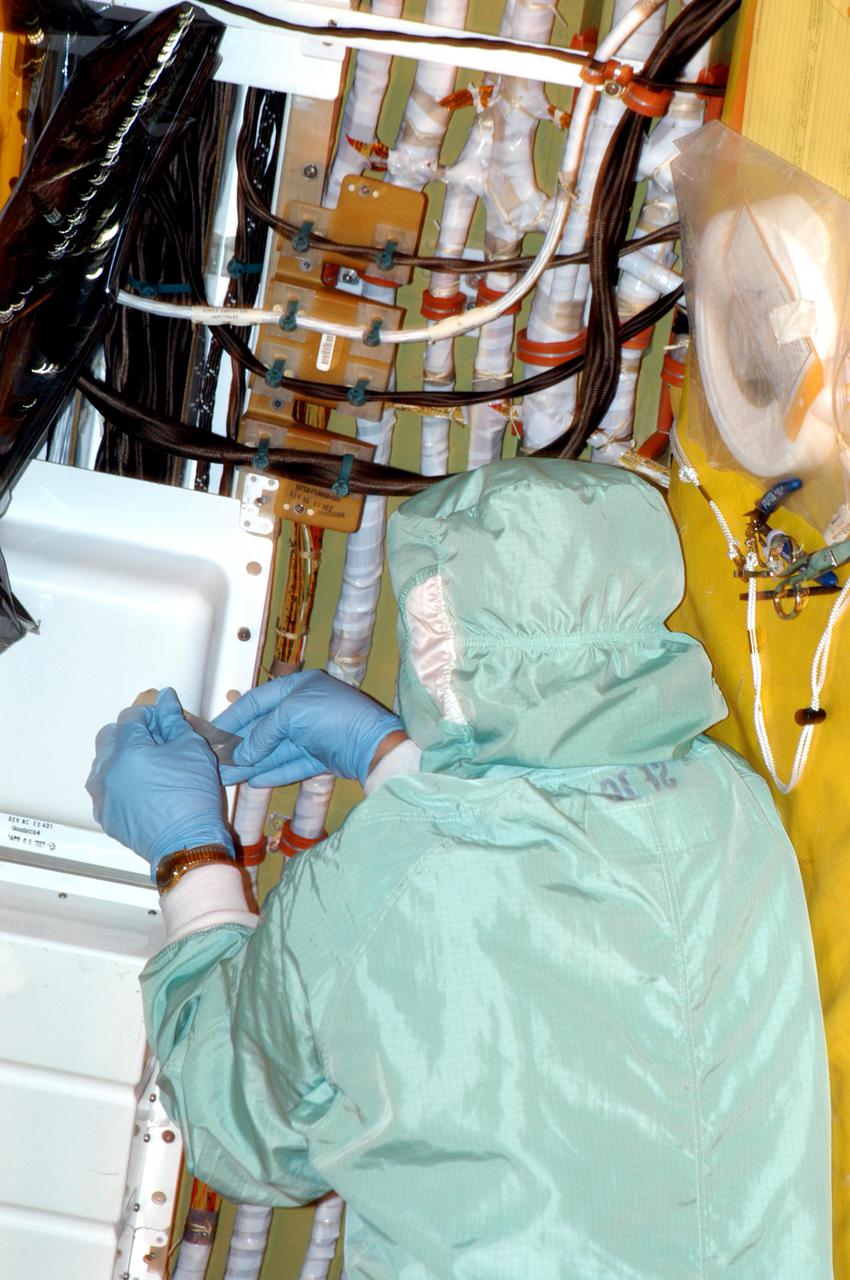 KENNEDY SPACE CENTER, FLA.  - In the Orbiter Processing Facility at NASA’s Kennedy Space Center in Florida, a worker are removing wire tray covers on Discovery and adding chafe prevention.  Boroscope inspections revealed the need for the protection to prevent fasteners from causing minor chafing on the tubing surrounding the wires.  Discovery is the designated orbiter for Return to Flight mission STS-114 to the International Space Station.  The launch window for the mission is May 15 to June 3, 2005.