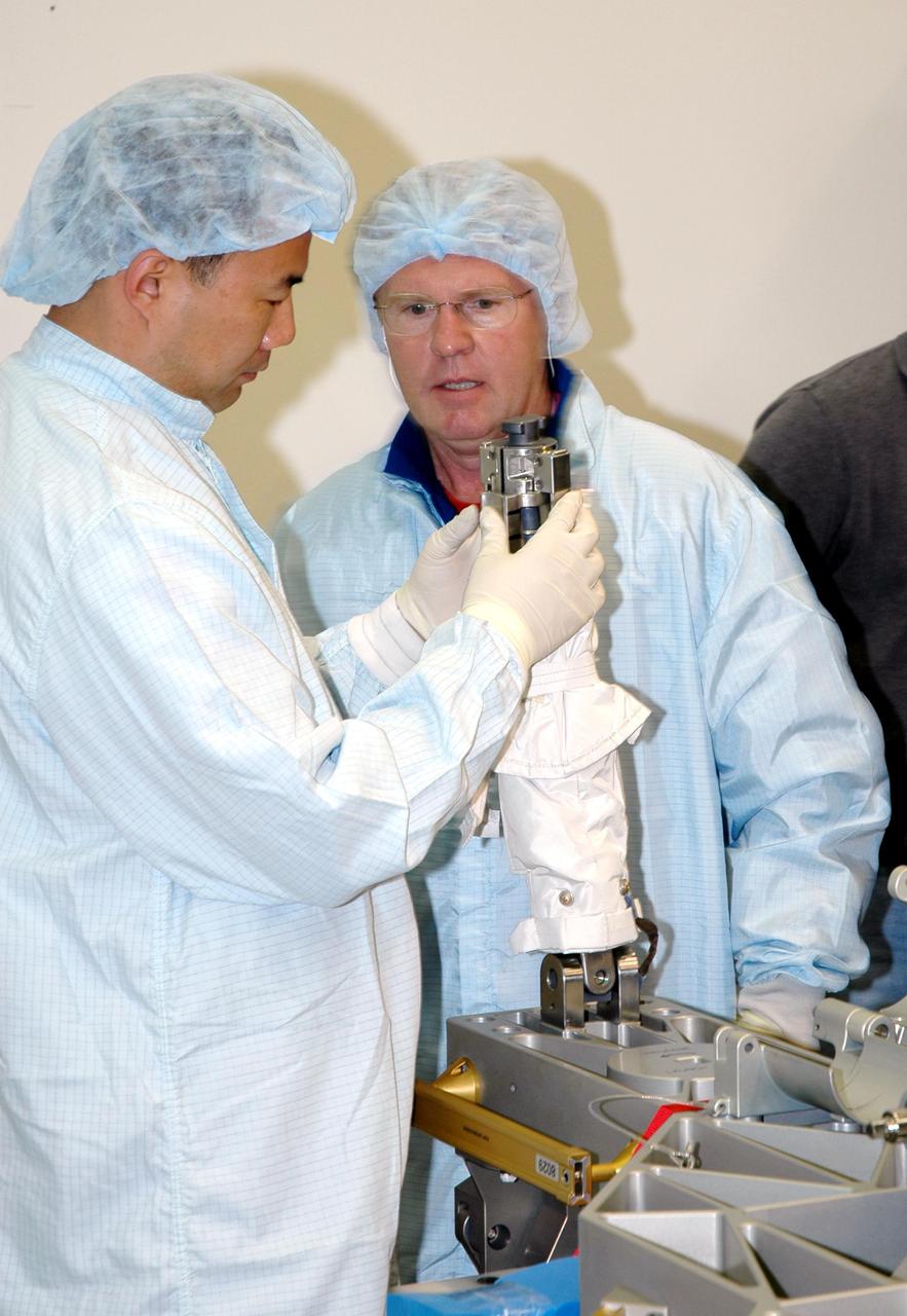 KENNEDY SPACE CENTER, FLA. - During Crew Equipment Interface Test (CEIT) at SPACEHAB in Cape Canaveral, Fla., STS-114 Mission Specialists Soichi Noguchi (left) and Andrew Thomas (right) check out a component on the External Stowage Platform-2 (ESP2). Noguchi is with the Japanese Aerospace Exploration Agency. As payload on Space Shuttle Discovery’s Return to Flight mission, the ESP2 will carry replacement parts, known as orbital replacement units (ORU) to the International Space Station. The platform will be deployed and attached to the Station’s airlock and will be used as a permanent spare parts facility. The launch window for STS-114 is May 15 to June 3, 2005. Earlier, during CEIT in the Space Station Processing Facility, the crew also inspected the resupply stowage racks installed in the Italian-built Multi-Purpose Logistics Module Raffaello and performed tool and equipment interface checks with the Thermal Protection System (TPS) repair sample box, and the Control Moment Gyroscope (CMG) in preparation for the mission’s three scheduled spacewalks. The seven-member crew will fly to the Space Station primarily to evaluate procedures for flight safety, including Shuttle inspection and repair techniques.