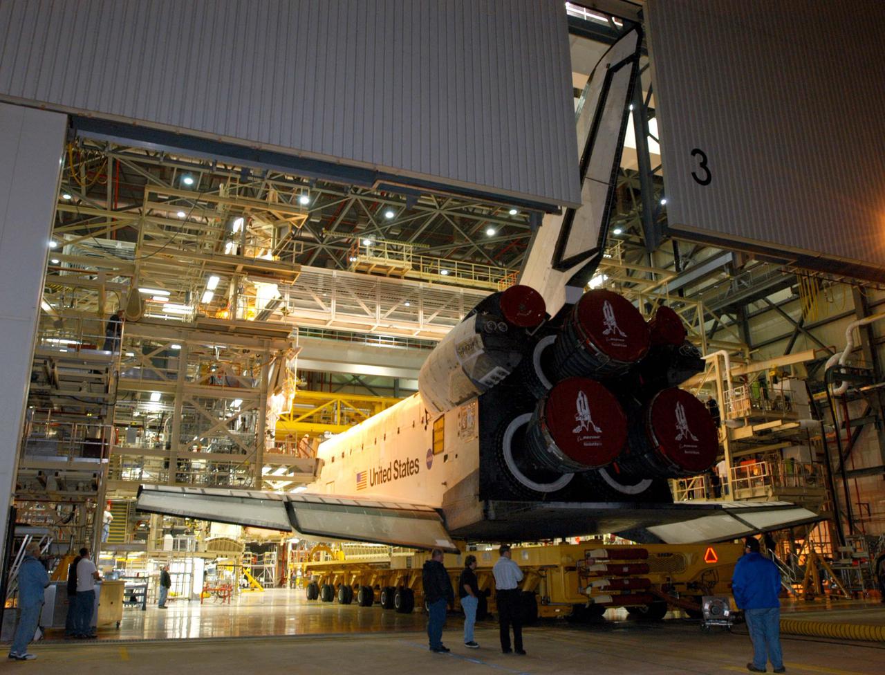 KENNEDY SPACE CENTER, FLA. - The orbiter Discovery slowly rolls out of the Orbiter Processing Facility bay 3 to begin its transfer to the Vehicle Assembly Building. First motion was at 1:29 a.m. EST. Inside the VAB, Discovery will be mated to the External Tank_Solid Rocket Booster assembly for Return to Flight mission STS-114. After all umbilicals have been connected, workers will perform an electrical and mechanical verification of the mated interfaces to verify all critical vehicle connections. A Space Shuttle interface test is performed to verify vehicle interfaces and vehicle-to-ground interfaces. The launch processing system is used to control and monitor orbiter systems as required. Space Shuttle Discovery will roll out to Launch Pad 39B approximately one week after the rollover to the VAB. The launch window for mission STS-114 is May 15 to June 3.