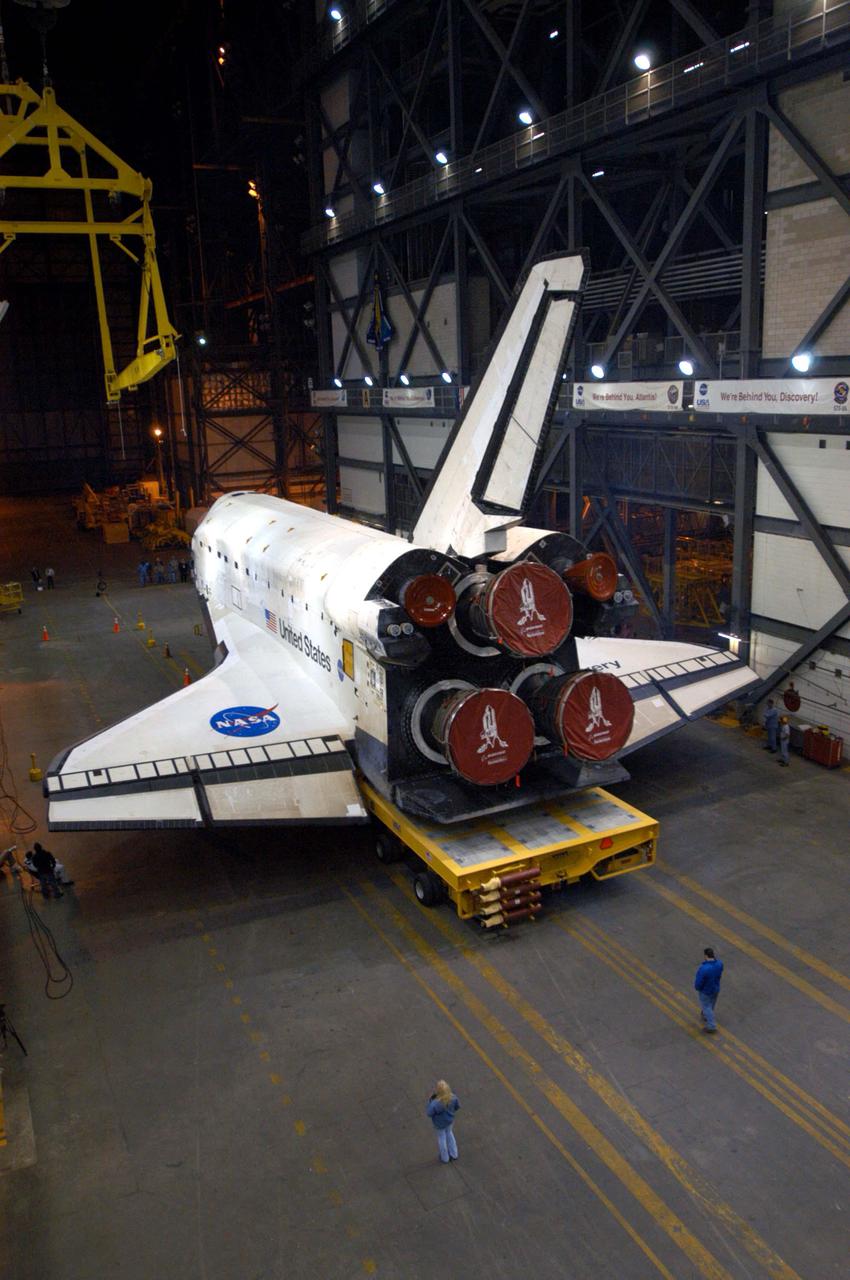 KENNEDY SPACE CENTER, FLA. - The orbiter Discovery rests in the transfer aisle of the Vehicle Assembly Building (VAB) after rollover from the Orbiter Processing Facility (OPF) bay 3. This marks a major milestone in the march to Return to Flight. First motion in the OPF was at 1:29 a.m. EST. Inside the VAB, Discovery will be mated to the External Tank_Solid Rocket Booster assembly for Return to Flight mission STS-114. After all umbilicals have been connected, workers will perform an electrical and mechanical verification of the mated interfaces to verify all critical vehicle connections. A Space Shuttle interface test is performed to verify vehicle interfaces and vehicle-to-ground interfaces. The launch processing system is used to control and monitor orbiter systems as required. Space Shuttle Discovery will roll out to Launch Pad 39B approximately one week after the rollover to the VAB. The launch window for mission STS-114 is May 15 to June 3.