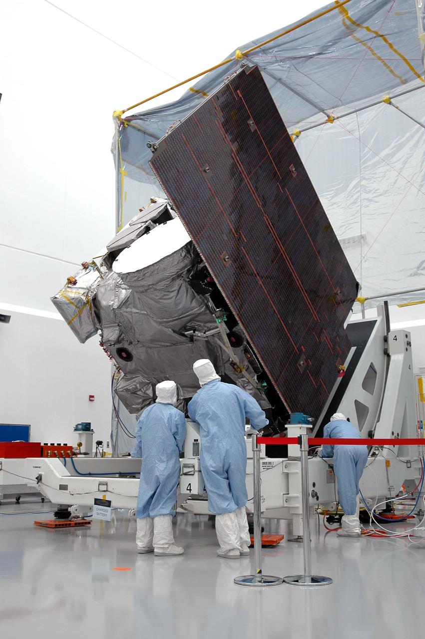 KENNEDY SPACE CENTER, FLA. - At Astrotech in Titusville, Fla., Boeing technicians observe the GOES-N satellite as it rotates to a vertical position. Seen on the right side is the solar panel. Since its arrival on March 11, the satellite has been undergoing final testing by Boeing Satellite Systems of the imaging system, instrumentation, communications and power systems. Geostationary Operational Environmental Satellites (GOES) are sponsored by NASA’s Goddard Space Flight Center and the National Oceanic and Atmospheric Administration. GOES-N is targeted to launch May 4 onboard a Boeing expendable launch vehicle Delta IV (4,2) with a 3-burn second stage operation.