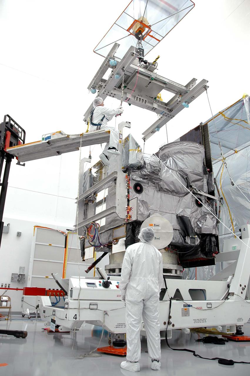 KENNEDY SPACE CENTER, FLA. - At Astrotech in Titusville, Fla., a Boeing technician on a lift above the GOES-N satellite completes attachment of the overhead crane. The crane will lift the satellite from the rotation stand and move it to a work stand. The crane is moving the satellite to a work stand. Since its arrival on March 11, the satellite has been undergoing final testing by Boeing Satellite Systems of the imaging system, instrumentation, communications and power systems. Geostationary Operational Environmental Satellites (GOES) are sponsored by NASA’s Goddard Space Flight Center and the National Oceanic and Atmospheric Administration. GOES-N is targeted to launch May 4 onboard a Boeing expendable launch vehicle Delta IV (4,2) with a 3-burn second stage operation.