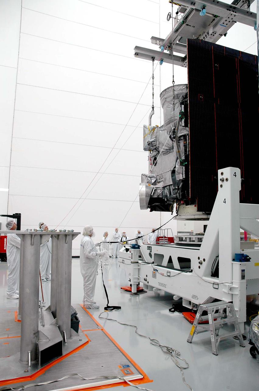 KENNEDY SPACE CENTER, FLA. - At Astrotech in Titusville, Fla., Boeing technicians hold guide wires attached to the crane lifting the GOES-N satellite. Since its arrival on March 11, the satellite has been undergoing final testing by Boeing Satellite Systems of the imaging system, instrumentation, communications and power systems. Geostationary Operational Environmental Satellites (GOES) are sponsored by NASA’s Goddard Space Flight Center and the National Oceanic and Atmospheric Administration. GOES-N is targeted to launch May 4 onboard a Boeing expendable launch vehicle Delta IV (4,2) with a 3-burn second stage operation.