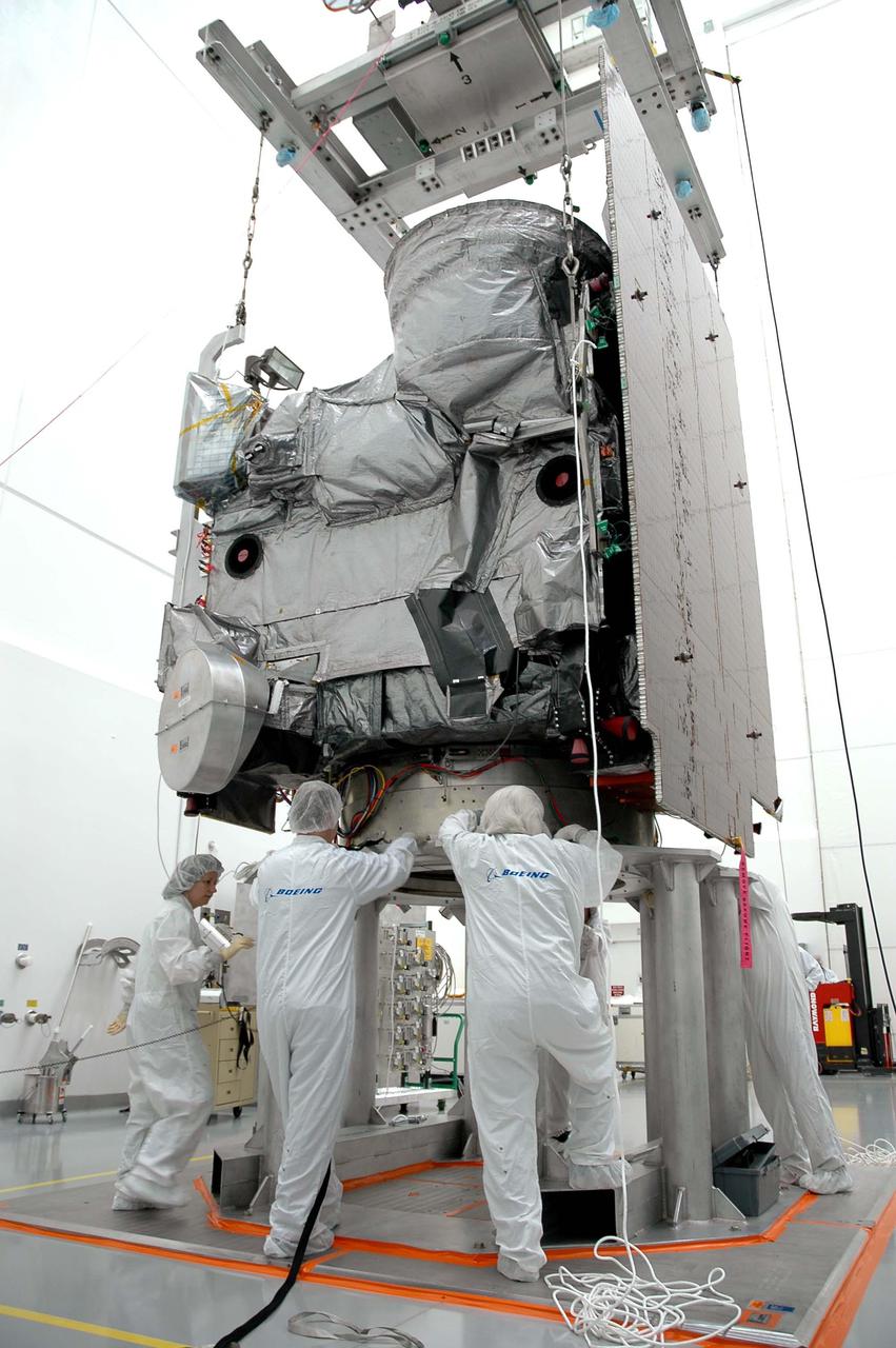 KENNEDY SPACE CENTER, FLA. - Astrotech in Titusville, Fla., Boeing technicians secure the GOES-N satellite on a work stand. Since its arrival on March 11, the satellite has been undergoing final testing by Boeing Satellite Systems of the imaging system, instrumentation, communications and power systems. Geostationary Operational Environmental Satellites (GOES) are sponsored by NASA’s Goddard Space Flight Center and the National Oceanic and Atmospheric Administration. GOES-N is targeted to launch May 4 onboard a Boeing expendable launch vehicle Delta IV (4,2) with a 3-burn second stage operation.