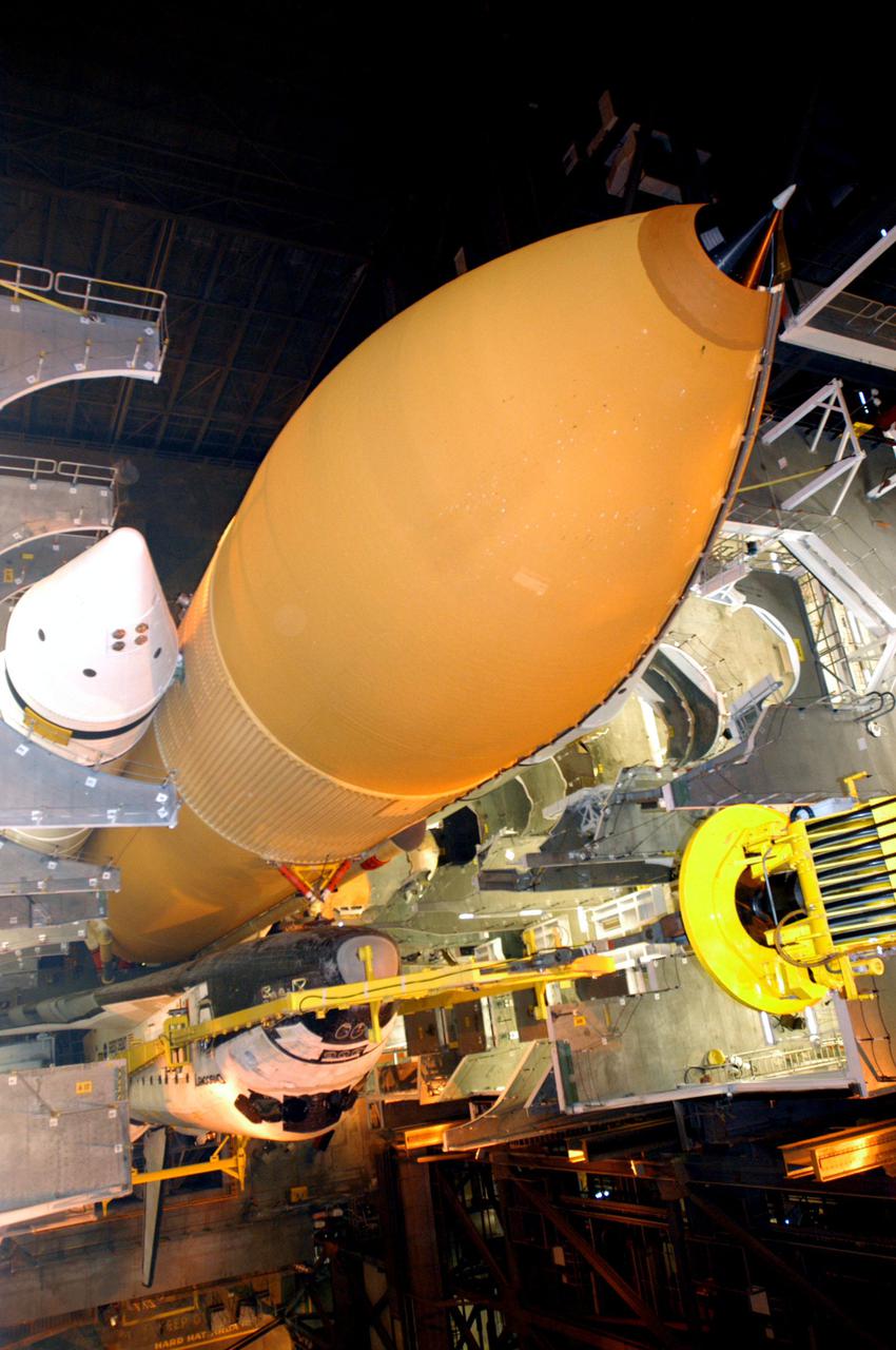 KENNEDY SPACE CENTER, FLA. - Inside the Vehicle Assembly Building at NASA’s Kennedy Space Center, the Solid Rocket Booster and External Tank stack, center, are viewed from above, with the orbiter Discovery in front of them on the Mobile Launcher Platform (MLP). After Discovery has been mated to the External Tank_Solid Rocket Booster assembly on the MLP and all umbilicals have been connected, workers will perform an electrical and mechanical verification of the mated interfaces to verify all critical vehicle connections. A Shuttle interface test is performed using the launch processing system to verify Space Shuttle vehicle interfaces and Space Shuttle vehicle-to-ground interfaces. In approximately one week, Space Shuttle Discovery will be ready for rollout to Launch Pad 39B for Return to Flight mission STS-114. The launch window for STS-114 is May 15 to June 3.