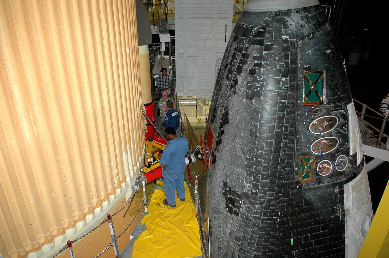 KENNEDY SPACE CENTER, FLA. - In the Vehicle Assembly Building at NASA’s Kennedy Space Center, workers mate the External Tank, at left, to the underside of Space Shuttle Discovery, at right. Each of two aft external tank umbilical plates mate with a corresponding plate on the orbiter. The plates help maintain alignment among the umbilicals. The attach fitting is aft of the nose gear wheel well. Workers next will perform an electrical and mechanical verification of the mated interfaces to verify all critical vehicle connections. A Shuttle interface test is performed using the launch processing system to verify Space Shuttle vehicle interfaces and Space Shuttle vehicle-to-ground interfaces. In approximately one week, Space Shuttle Discovery will be ready for rollout to Launch Pad 39B for Return to Flight mission STS-114. The launch window for STS-114 is May 15 to June 3.