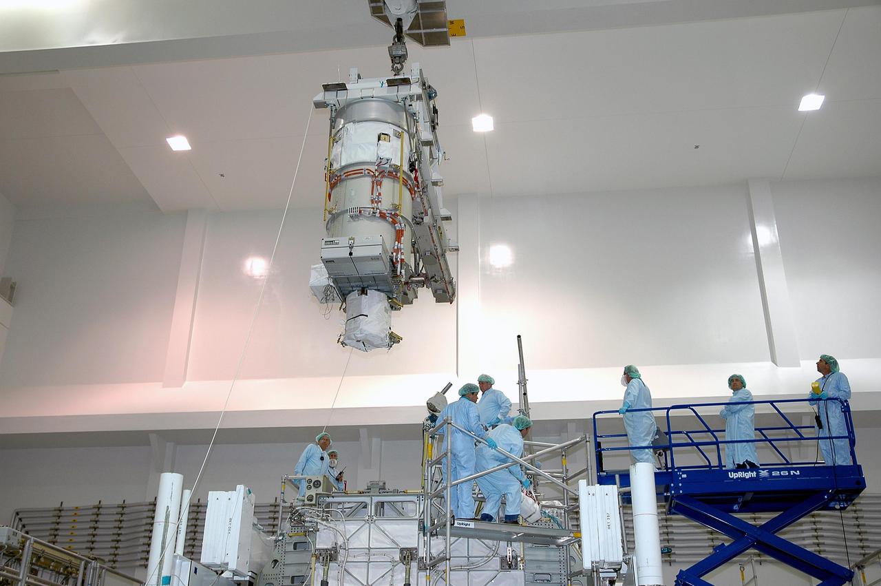 KENNEDY SPACE CENTER, FLA. - In the Space Station Processing Facility, an overhead crane lifts the lower deck solar array wing scheduled to launch on International Space Station mission 12A, STS-115. The solar array is being removed in preparation for replacement of aging flight batteries. The currently installed batteries have an expected on-orbit lifetime of approximately four years. New batteries are being installed to ensure that the batteries do not exceed their lifetime expectancy prior to their planned logistics resupply on-orbit. The new batteries will have a lifetime expectancy of approximately 7 years.