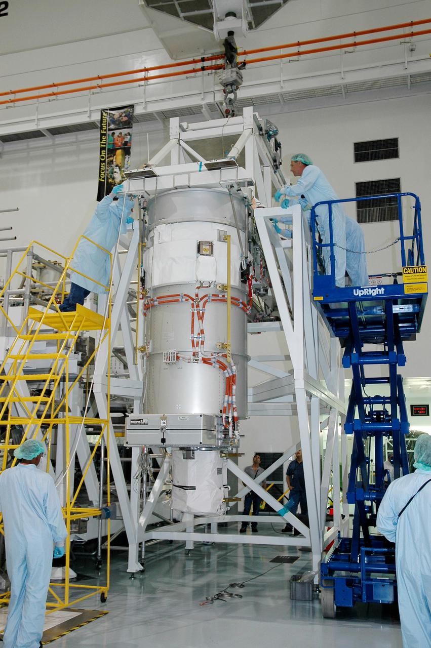 KENNEDY SPACE CENTER, FLA. - In the Space Station Processing Facility, the lower deck solar array wing scheduled to launch on International Space Station mission 12A, STS-115, is lowered onto a work stand. The solar array is being removed in preparation for replacement of aging flight batteries. The currently installed batteries have an expected on-orbit lifetime of approximately four years. New batteries are being installed to ensure that the batteries do not exceed their lifetime expectancy prior to their planned logistics resupply on-orbit. The new batteries will have a lifetime expectancy of approximately 7 years.