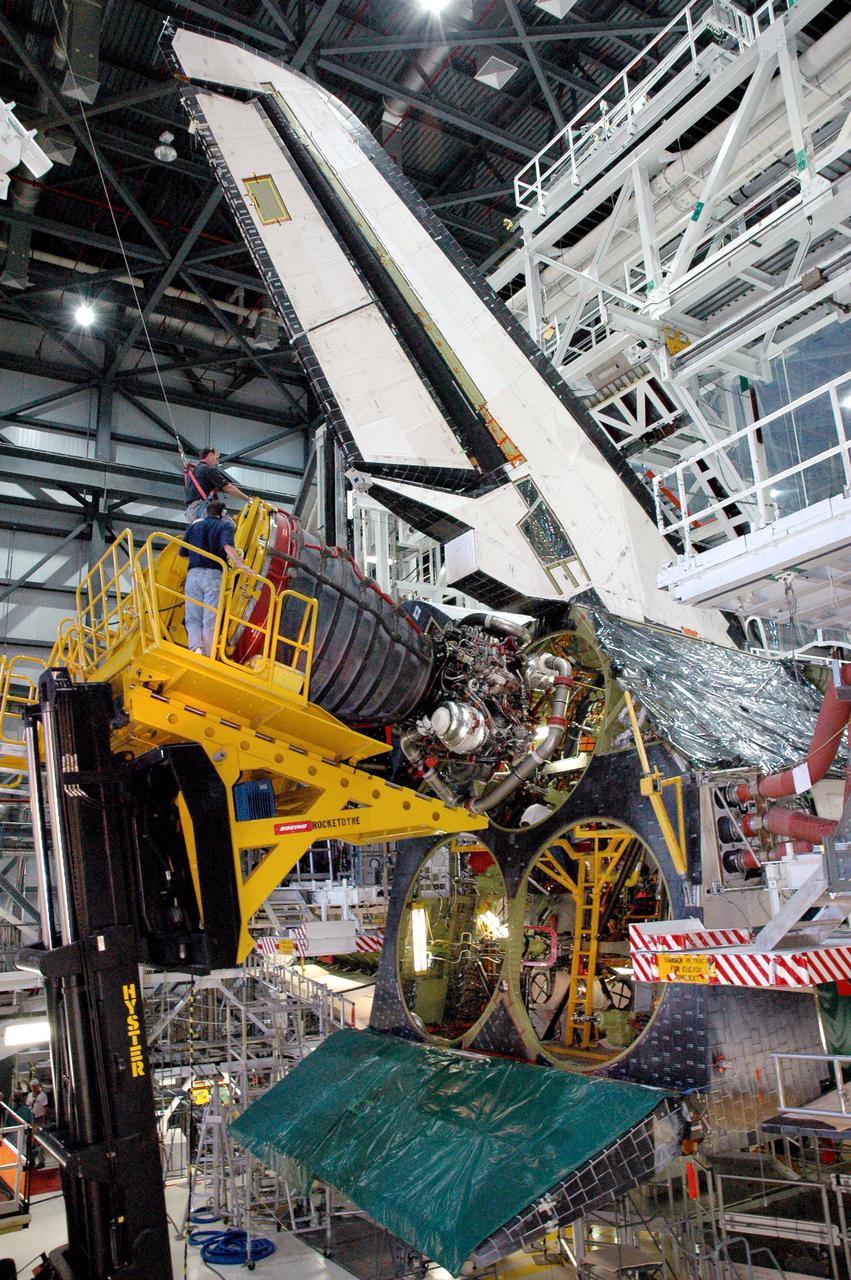 KENNEDY SPACE CENTER, FLA. -  In the Orbiter Processing Facility bay 1 at NASA’s Kennedy Space Center, a Space Shuttle Main Engine (SSME), held by a Hyster fork lift, is maneuvered into place in position number one (upper chamber) in Atlantis.  Overall, an SSME weighs approximately 7,000 pounds. Three engines provide the thrust, along with the two Solid Rocket Boosters, for liftoff.  After about 2 minutes, the two boosters are spent and are separated from the external tank. The SSMEs continue firing for about 8 minutes. They shut down just before the craft is inserted into orbit.  The SSMEs are tested at Stennis Space Center in Mississippi.  Atlantis is being processed for the second Return to Flight mission, STS-121, scheduled for launch in a window from July 12 through July 31.