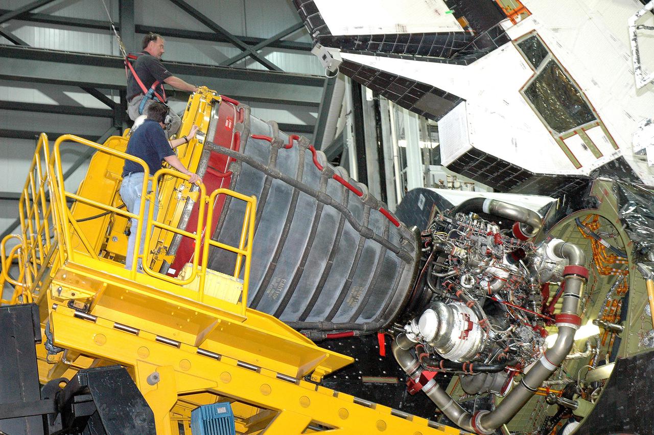 KENNEDY SPACE CENTER, FLA. -  In the Orbiter Processing Facility bay 1 at NASA’s Kennedy Space Center, workers guide the Hyster fork lift close to Atlantis to install a Space Shuttle Main Engine (SSME) in position number one (upper chamber).   Overall, an SSME weighs approximately 7,000 pounds. Three engines provide the thrust, along with the two Solid Rocket Boosters, for liftoff.  After about 2 minutes, the two boosters are spent and are separated from the external tank. The SSMEs continue firing for about 8 minutes. They shut down just before the craft is inserted into orbit.  The SSMEs are tested at Stennis Space Center in Mississippi.  Atlantis is being processed for the second Return to Flight mission, STS-121, scheduled for launch in a window from July 12 through July 31.