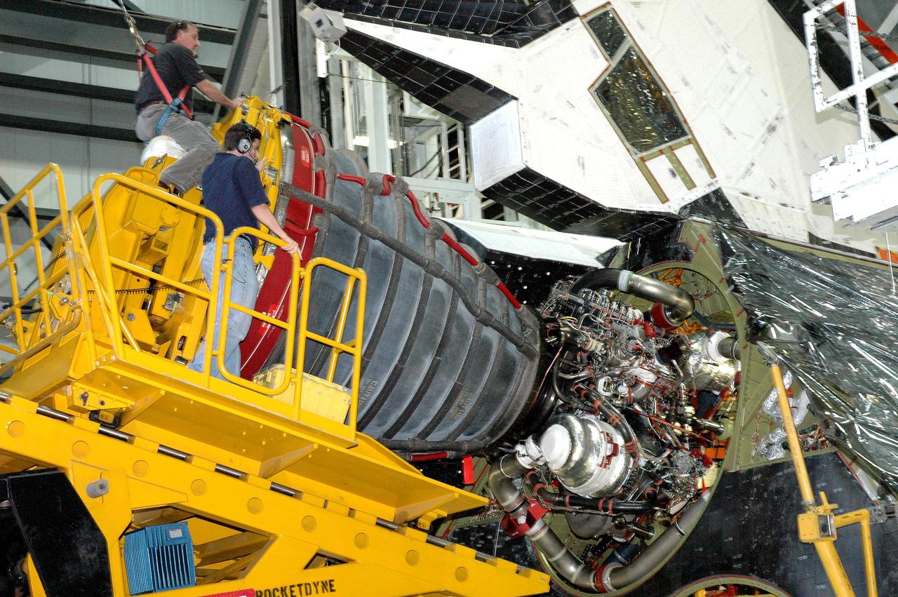 KENNEDY SPACE CENTER, FLA. -  In the Orbiter Processing Facility bay 1 at NASA’s Kennedy Space Center, workers guide the Hyster fork lift close to Atlantis to install a Space Shuttle Main Engine (SSME) in position number 1 (upper chamber).  Overall, an SSME weighs approximately 7,000 pounds. Three engines provide the thrust, along with the two Solid Rocket Boosters, for liftoff.  After about 2 minutes, the two boosters are spent and are separated from the external tank. The SSMEs continue firing for about 8 minutes. They shut down just before the craft is inserted into orbit.  The SSMEs are tested at Stennis Space Center in Mississippi.  Atlantis is being processed for the second Return to Flight mission, STS-121, scheduled for launch in a window from July 12 through July 31.