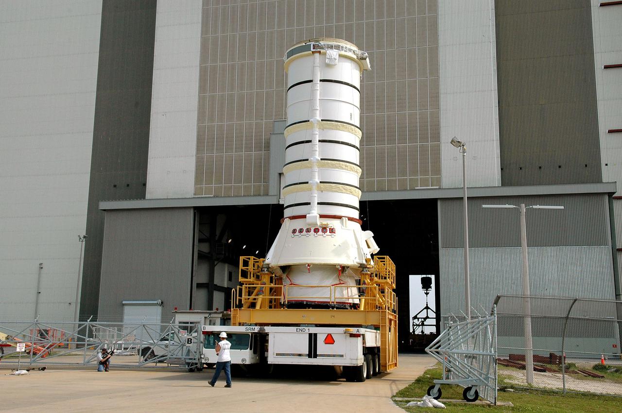 KENNEDY SPACE CENTER, FLA. - The aft segment of a Solid Rocket Booster rolls toward the opening in the Vehicle Assembly Building. The segment will be mated with other segments for use on the launch of Space Shuttle Atlantis on the second Return to Flight mission, STS-121. SRBs are used as matched pairs and each is made up of four solid rocket motor segments. Two SRBs provide the main thrust to lift the Space Shuttle off the pad to an altitude of about 150,000 feet. In addition, the two SRBs carry the entire weight of the External Tank and orbiter and transmit the weight load through their structure to the Mobile Launcher Platform. Each booster has a thrust (sea level) of approximately 3,300,000 pounds at launch, and provide 71.4 percent of the thrust at liftoff and during first-stage ascent.