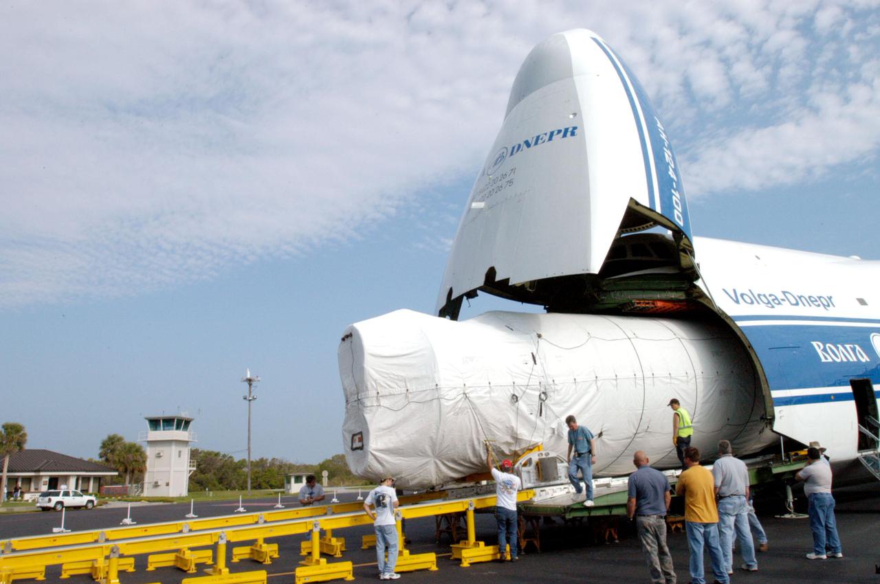 KENNEDY SPACE CENTER, FLA. - At the Cape Canaveral Air Force Station Skid Strip, the booster segment for a Lockheed Martin Atlas V is rolled out of a Russian Antonov AH-124-100 cargo airplane.  The Atlas V, designated AV-007, is the launch vehicle for the Mars Reconnaissance Orbiter (MRO).   The MRO is designed for a series of global mapping, regional survey and targeted observations from a near-polar, low-altitude Mars orbit. These observations will be unprecedented in terms of the spatial resolution and coverage achieved by the orbiter’s instruments as they observe the atmosphere and surface of Mars while probing its shallow subsurface as part of a “follow the water” strategy.  The orbiter is undergoing environmental tests in facilities at Lockheed Martin Space Systems in Denver, Colo., and is on schedule for a launch window that begins Aug. 10. Launch will be from Launch Pad 41 at Cape Canaveral Air Force Station in Florida.