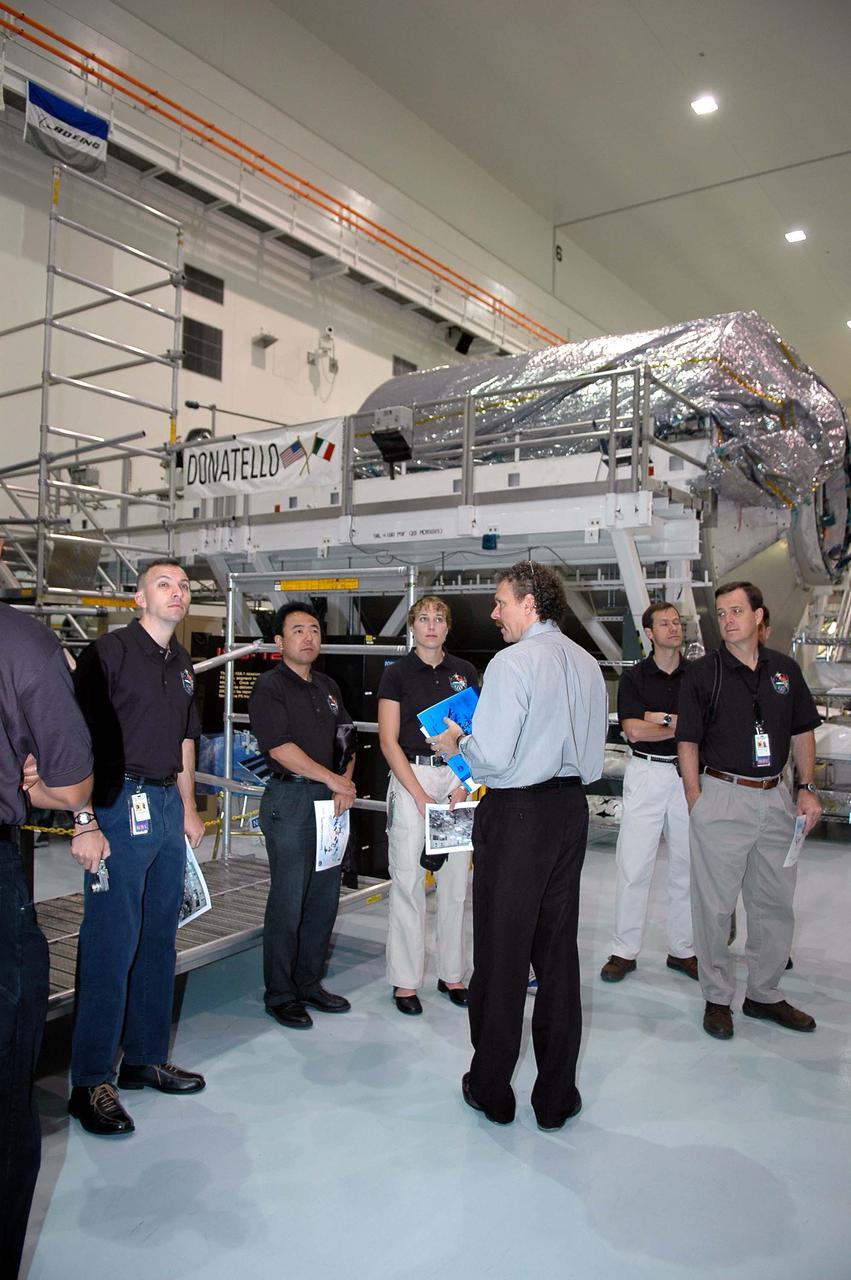KENNEDY SPACE CENTER, FLA. - At NASA’s Kennedy Space Center, Russell Romanella (in the foreground), deputy director of ISS and Payload Processing, talks to the 2004 class of astronaut candidates on their tour of the Space Station Processing Facility.  In the background is the Multi-Purpose Logistics Module Donatello.  The class of 14 candidates includes three candidates from the Japan Aerospace Exploration Agency as well as three educator astronauts, who were school teachers chosen from thousands of applicants.